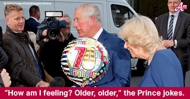 Prince Charles looks delighted and humble holding a fancy balloon at his 70th birthday