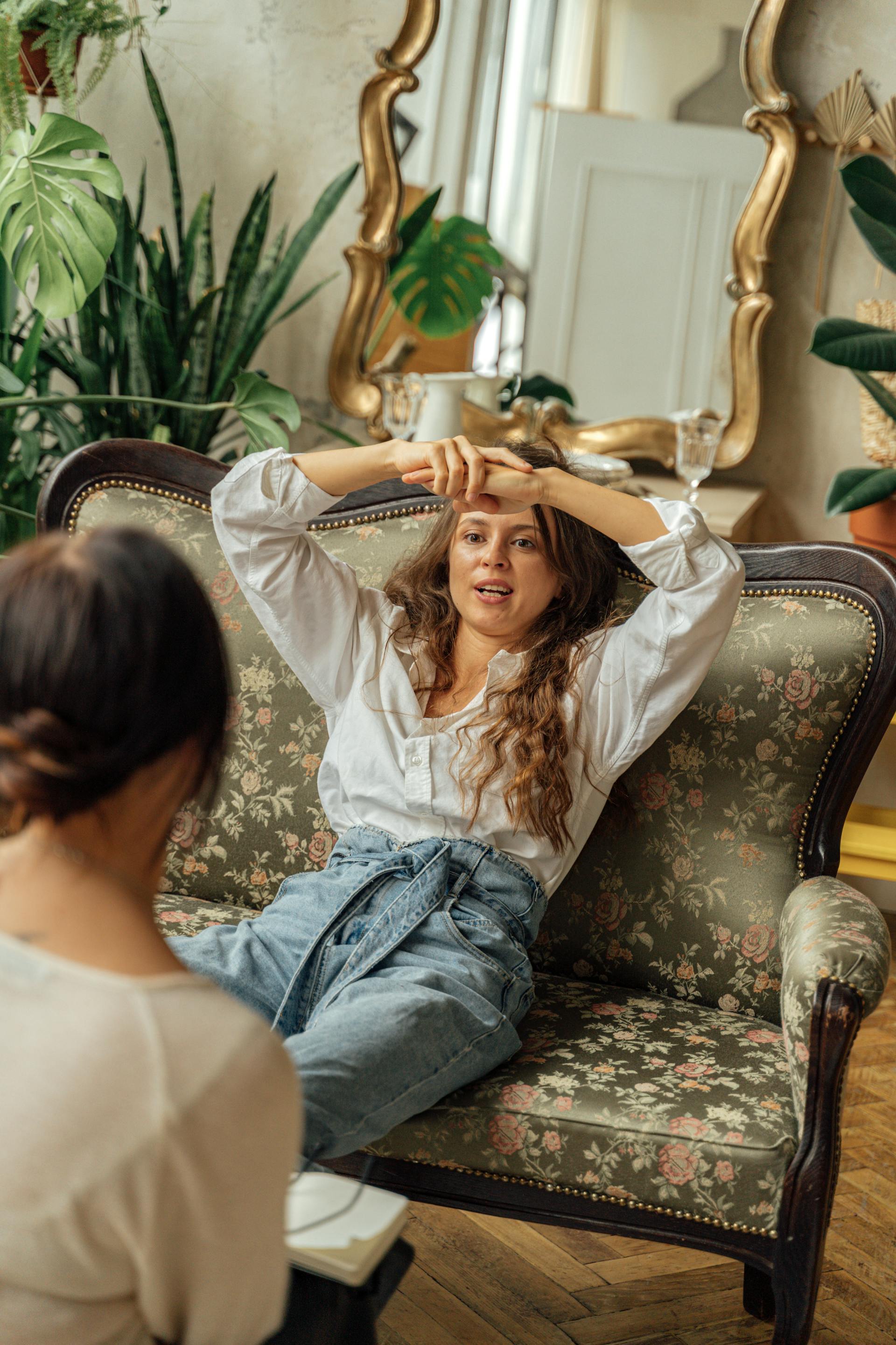 A woman sitting on a sofa and talking to her female friend | Source: Pexels