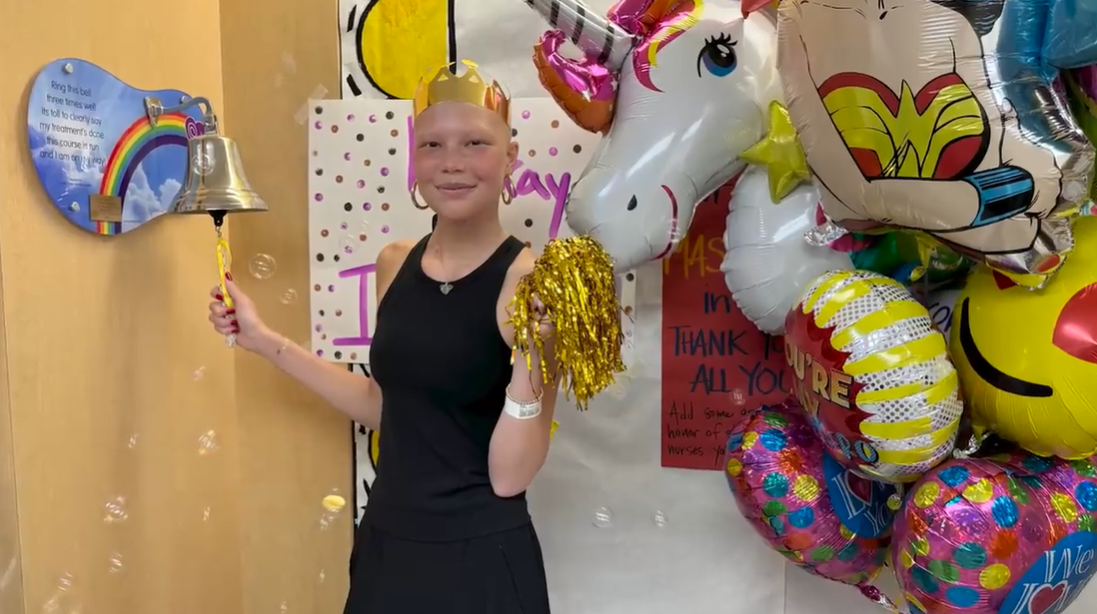 Isabella rings the bell, marking the end of her cancer treatment journey with a smile and gold crown, as posted on June 15, 2024 | Source: YouTube/IsabellaStrahan