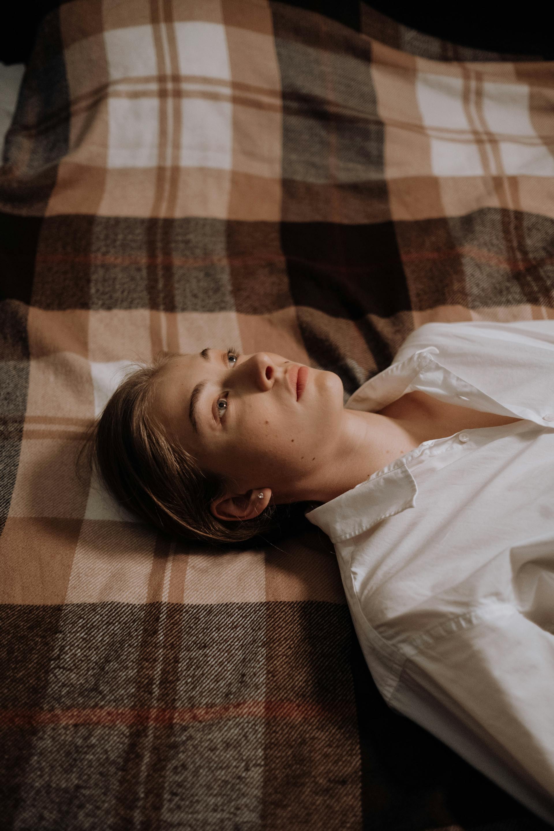 A woman lying awake in her bed | Source: Pexels