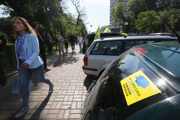 Photo of a woman walking past parked cars | Image: Getty Images