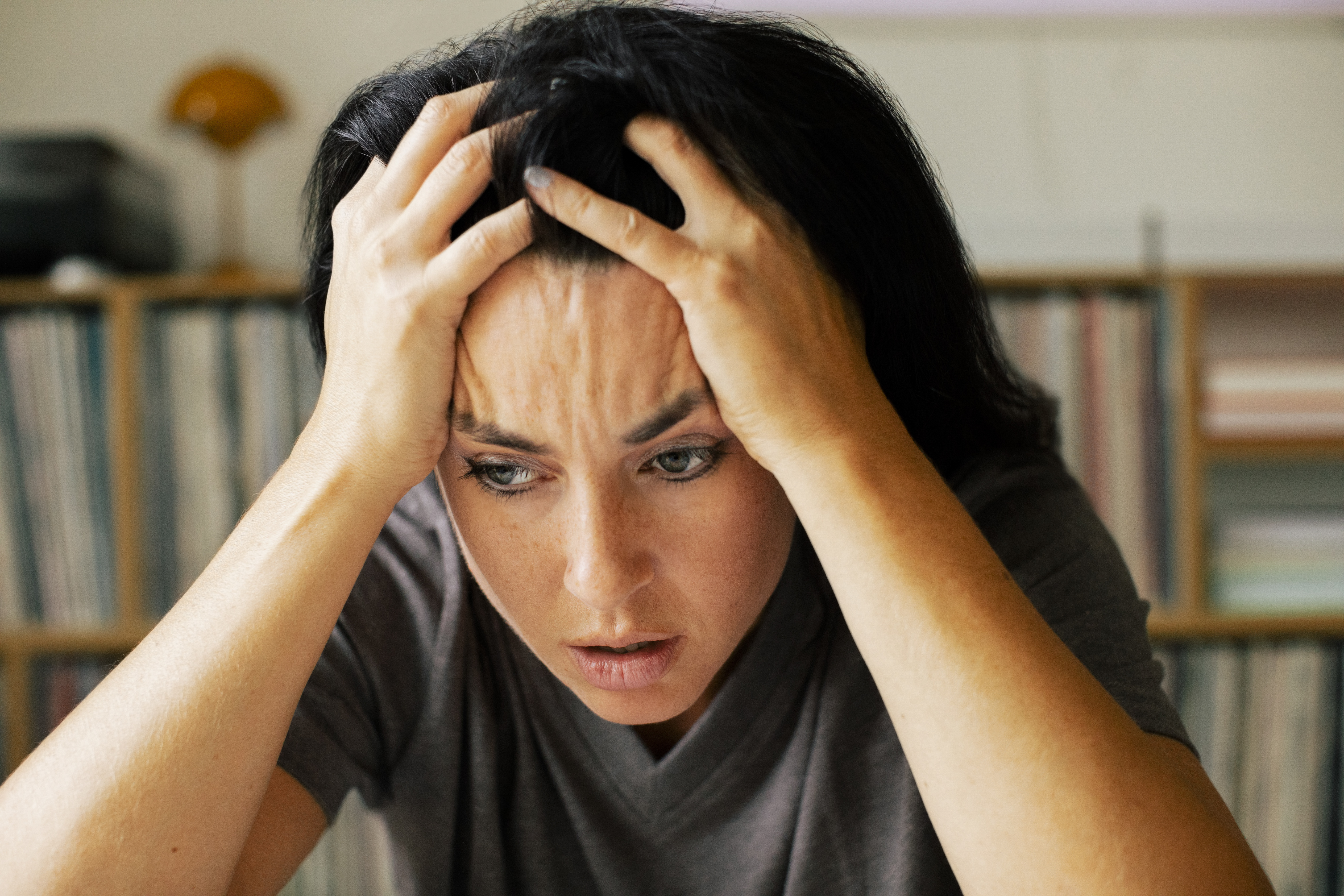 Stressed woman with head in hands at home | Source: Getty Images