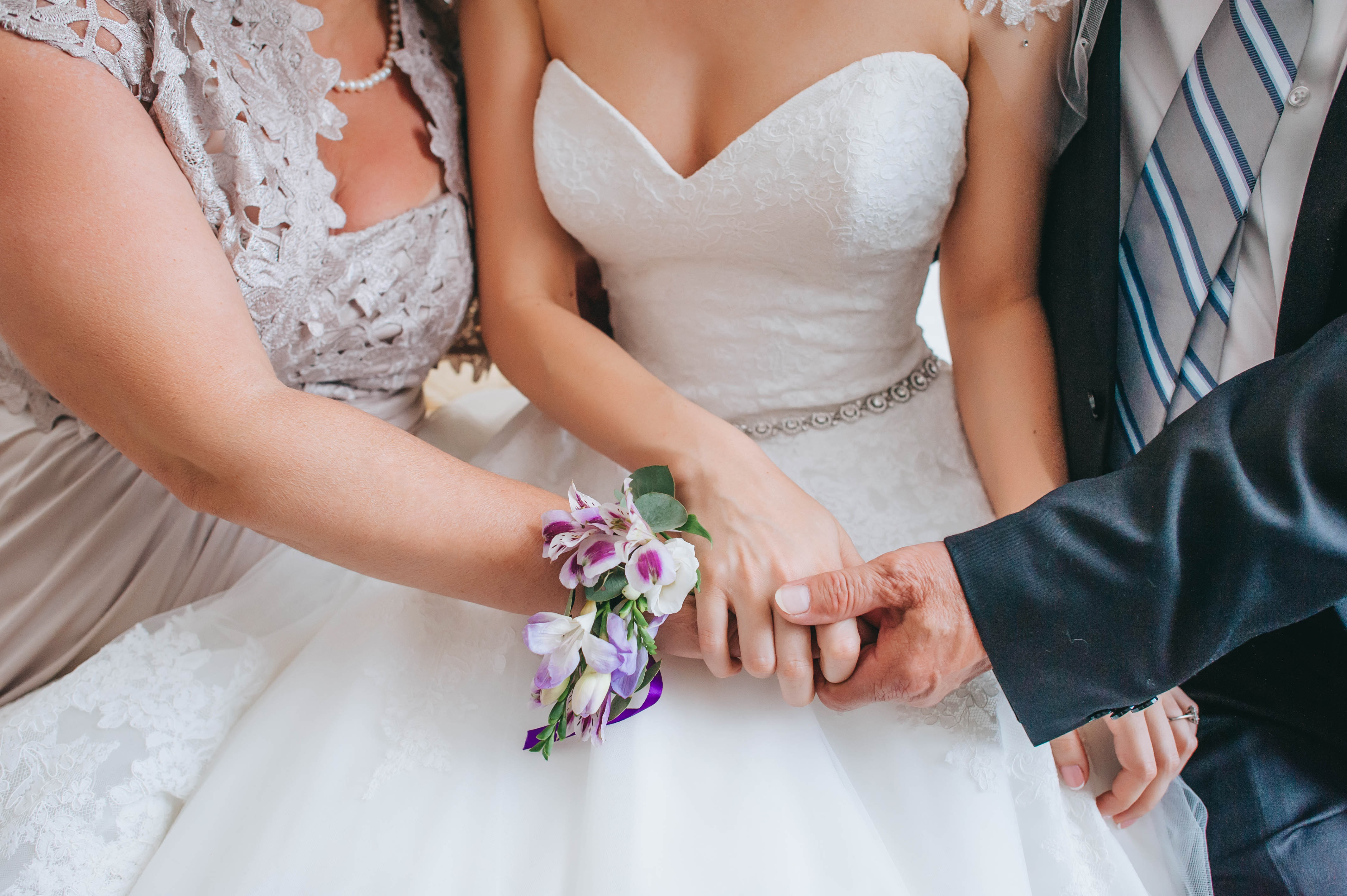 Parents holding their daughter's hand on her wedding day | Source: Shutterstock