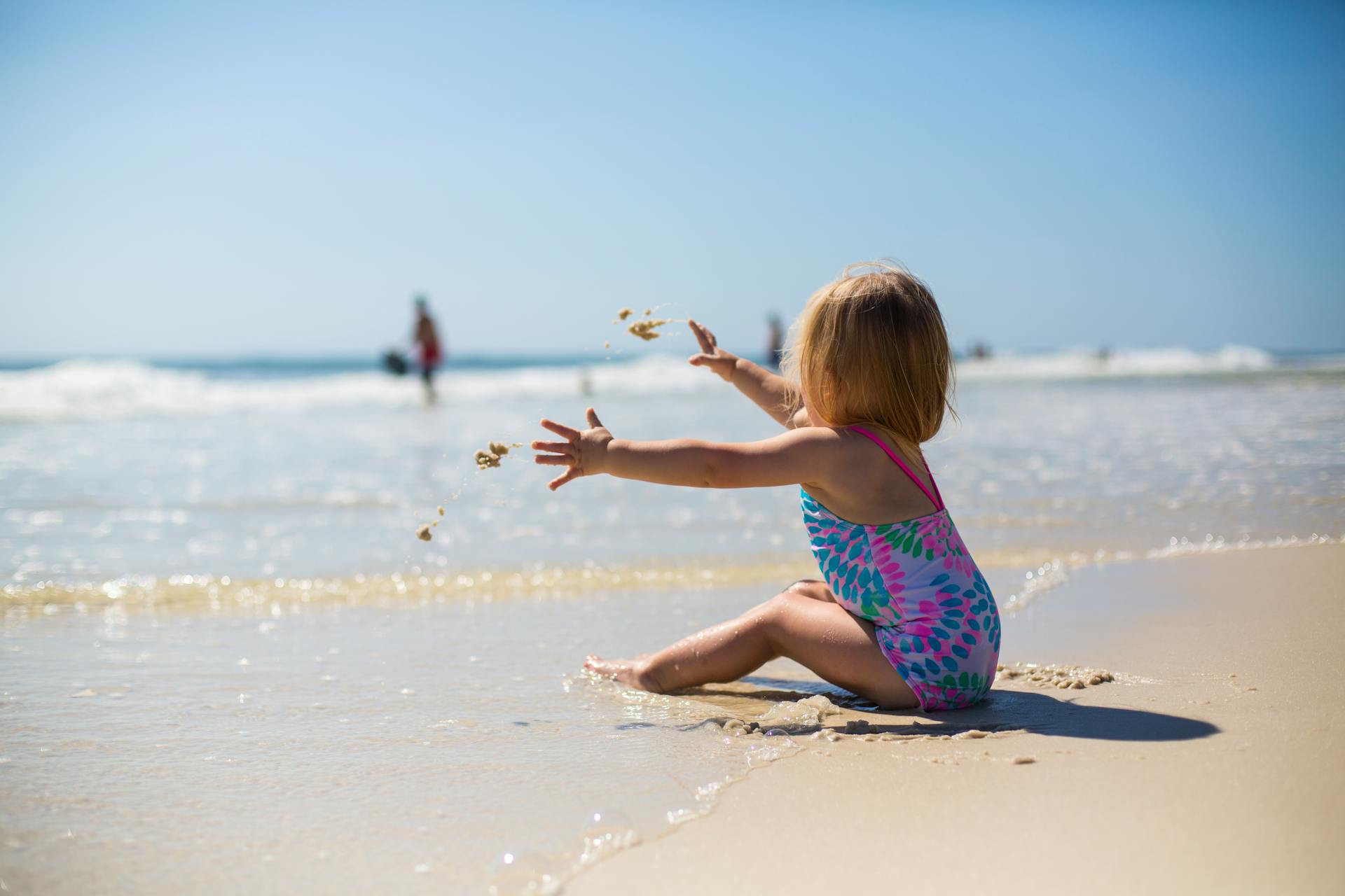 A girl throwing sand on the beach | Source: Pexels