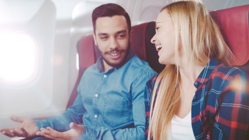 Un homme et une femme parlant dans un avion pendant leur vol Photo : Shutterstock Un homme et une femme parlant dans un avion pendant leur vol Photo : Shutterstock