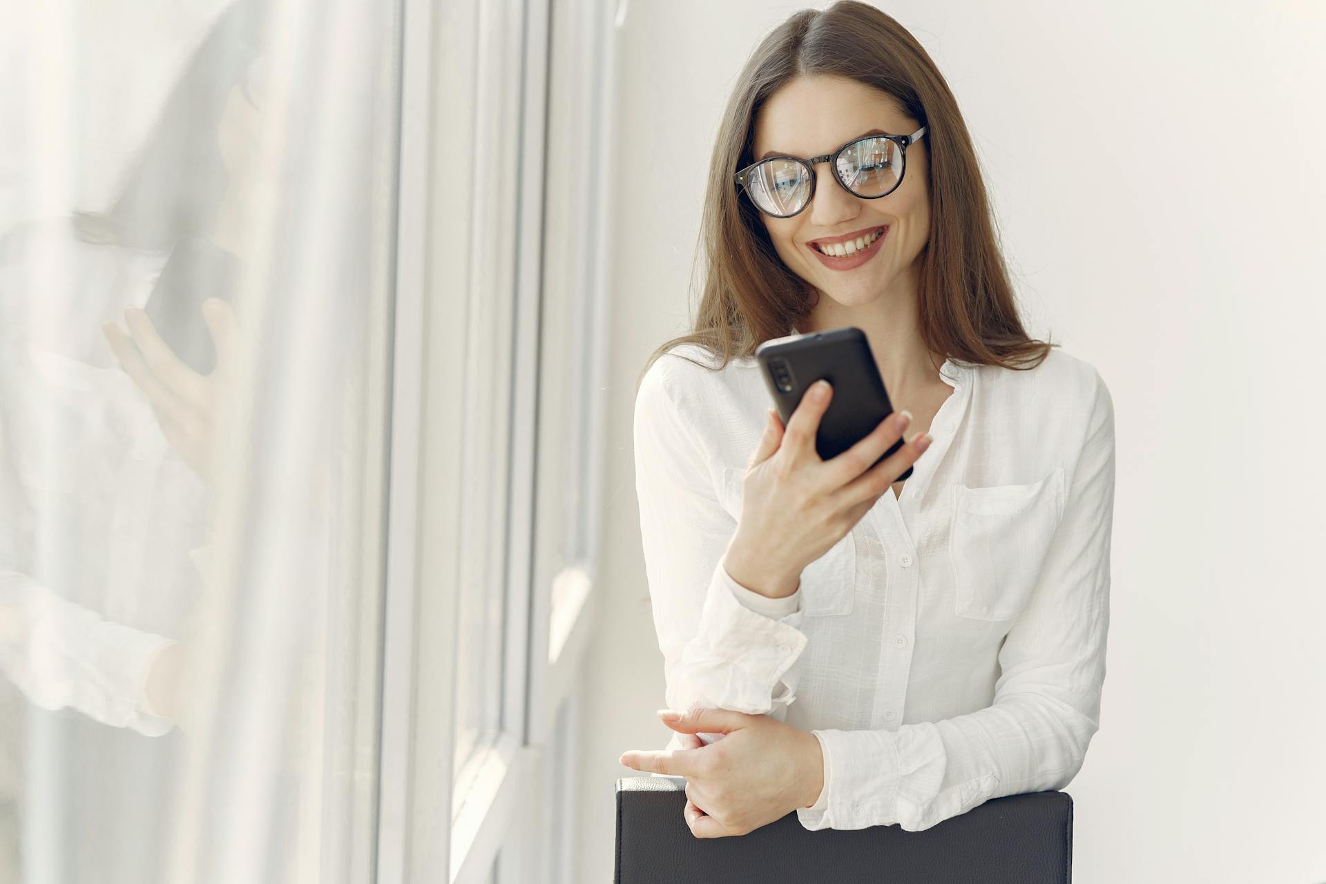 A woman using her phone at work | Source: Pexels