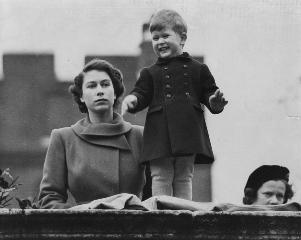 Princess Elizabeth watches Prince Charles smile as they wait to view the marriage procession of Queen Juliana and Prince Bernhard at Clarence House, London on November 22, 1950. | Source: Paul Popper/Popperfoto/Getty Images