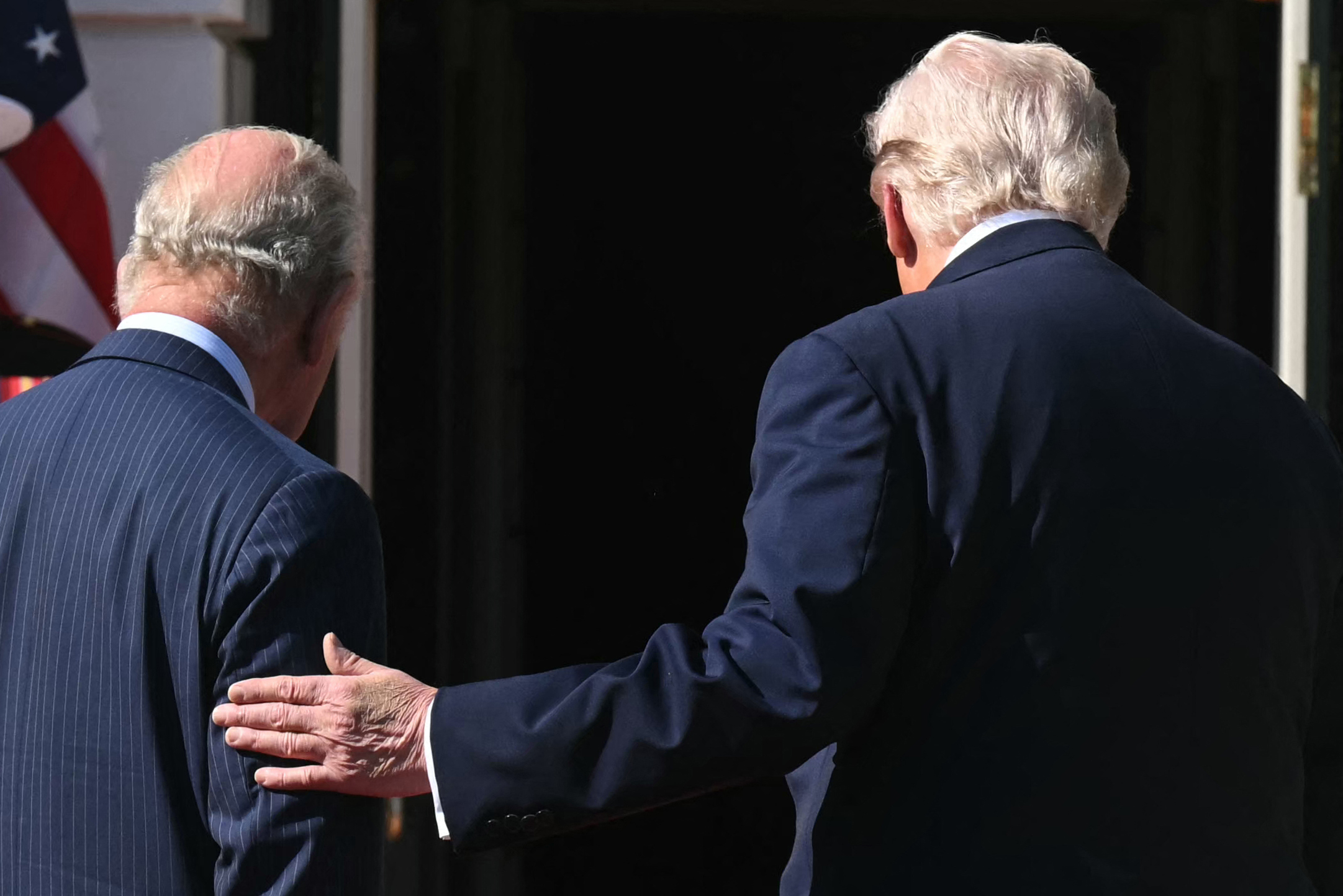 Donald Trump places a hand on King Charles III’s upper arm as they walk on April 27, 2026 | Source: Getty Images
