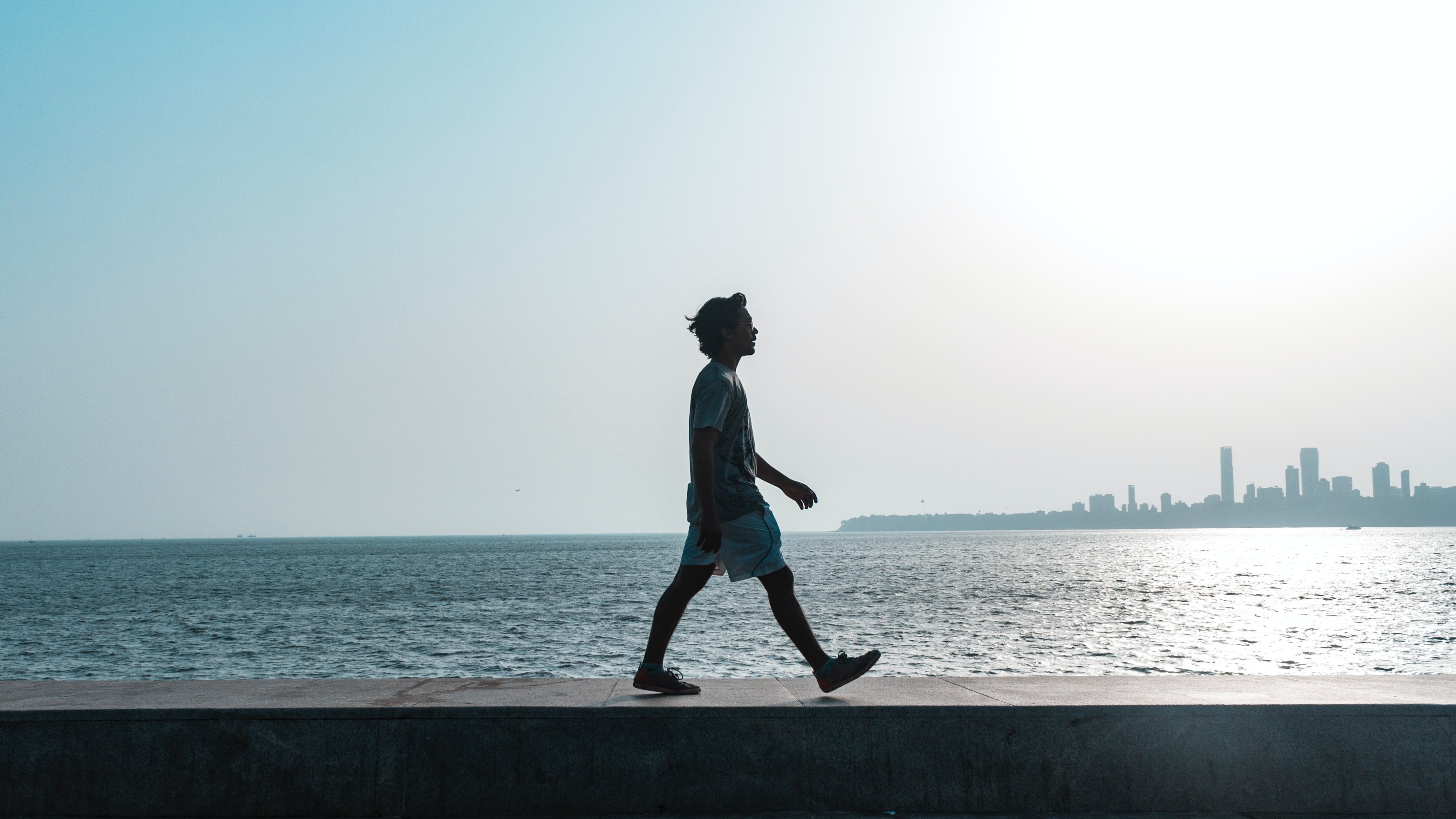 A man walking beside water | Photo: Pexels