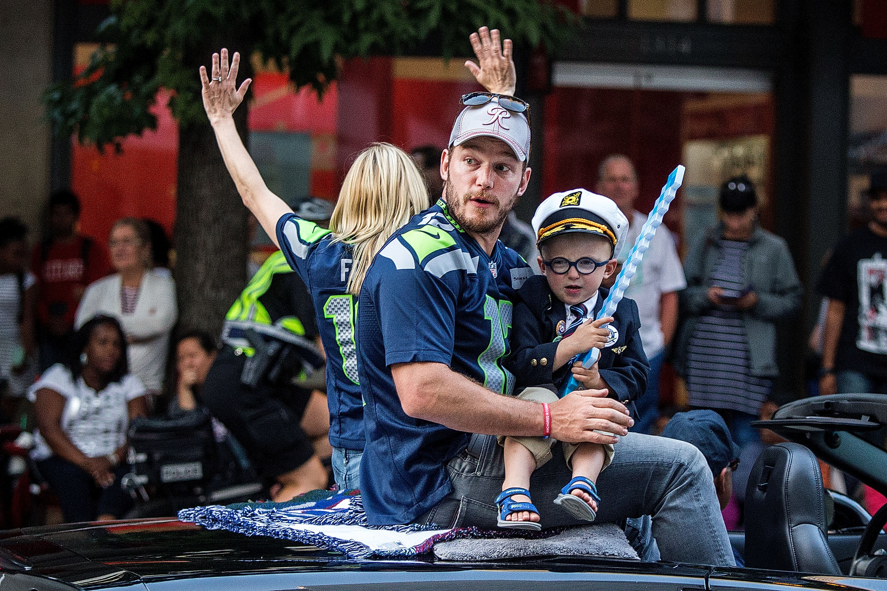 Chris Pratt and son Jack Pratt ride together in the Seafair Torchlight Parade Grand Marshal vehicle in Seattle. Dressed in a captain's hat and blazer, young Jack appeared ready for the festivities as he sat beside his father and greeted spectators along the parade route.