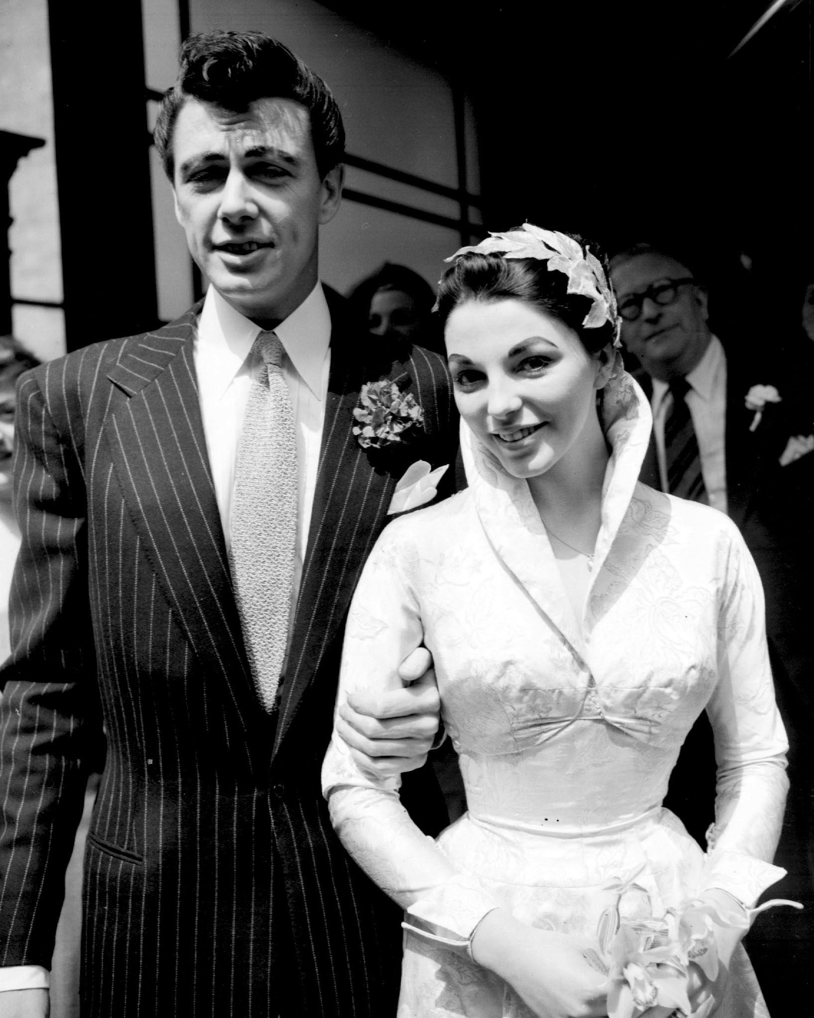 Actor Maxwell Reed and his bride Joan Collins after their wedding at Caxton Hall Register Office in 1952, in London. | Source: Getty Images