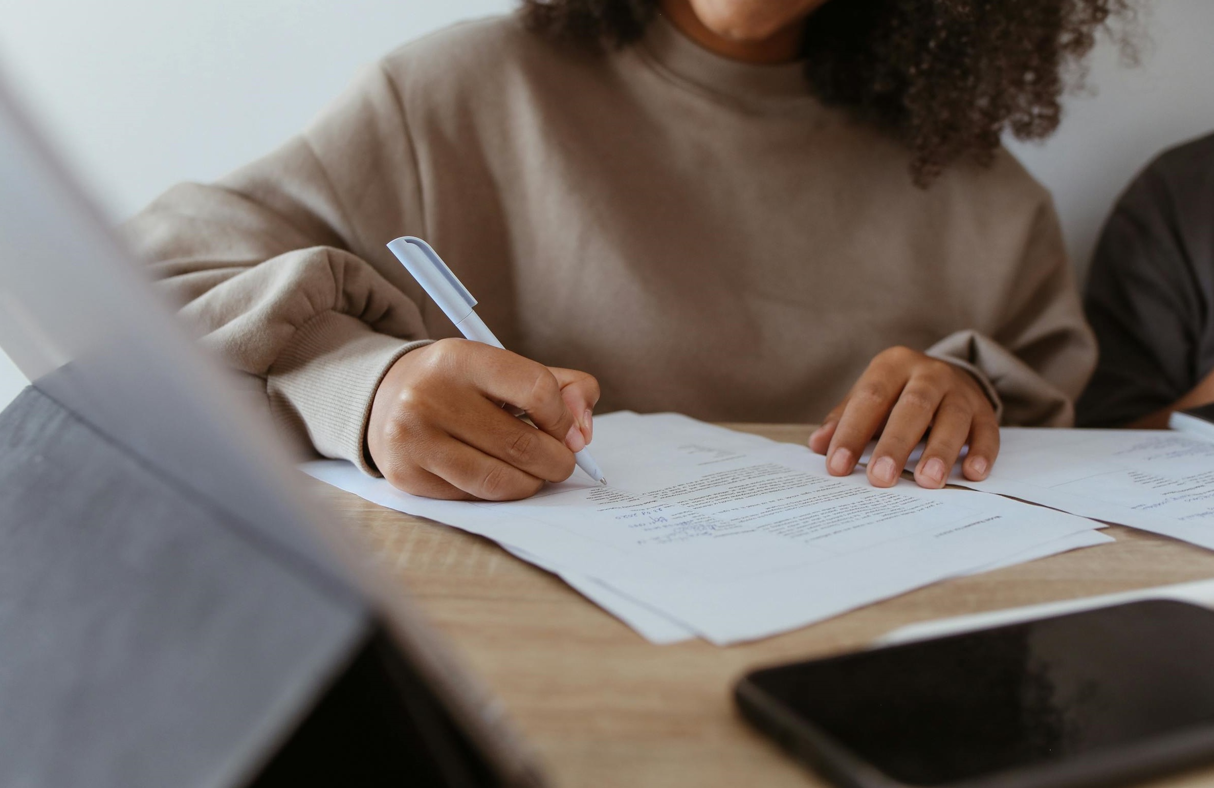 A woman signing paperwork | Source: Pexels