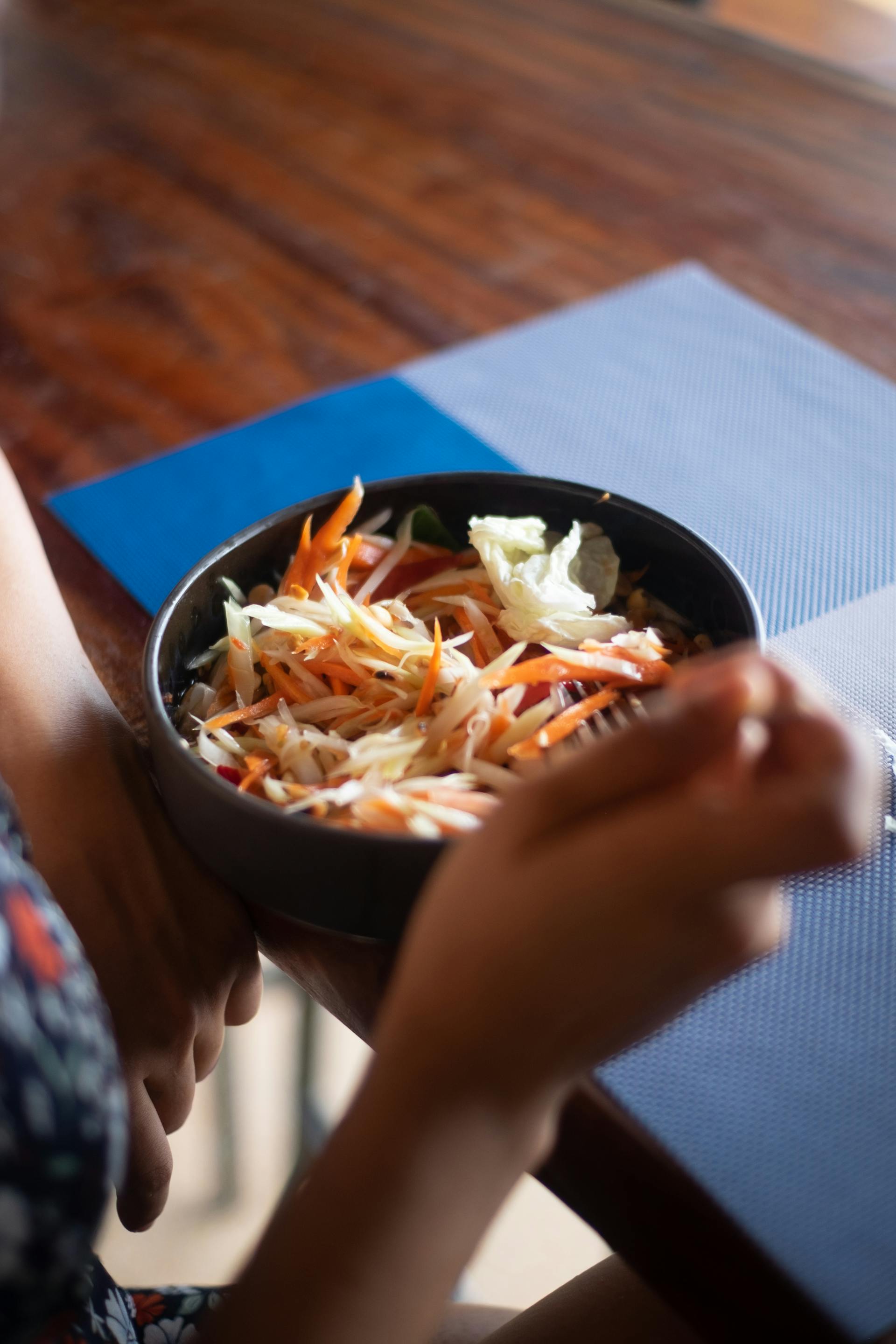 Close-up of a person eating salad at a restaurant | Source: Pexels