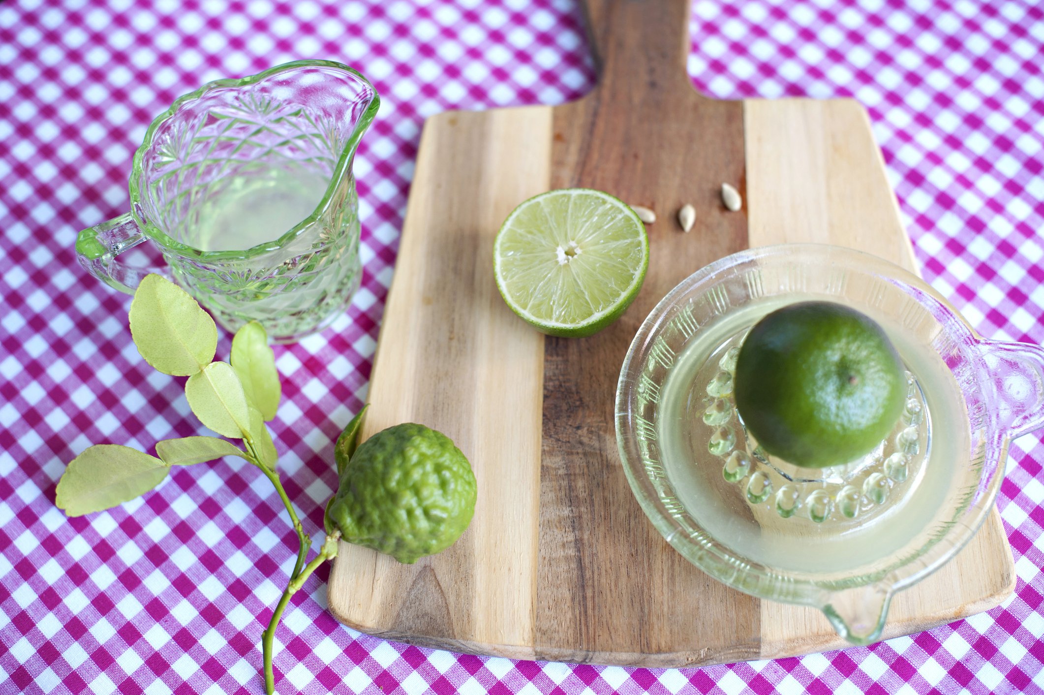 Freshly picked  lime being squeezed for fresh lime juice on a vintage green glass juicer. | Photo: Getty Images