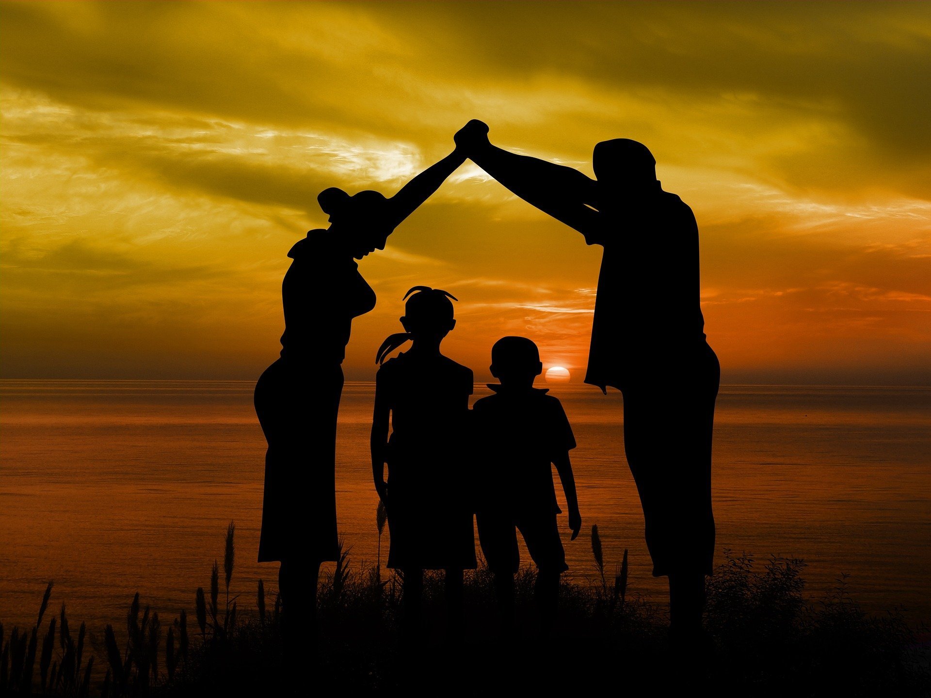 A silhouette of a family during sunset | Source: Pixabay