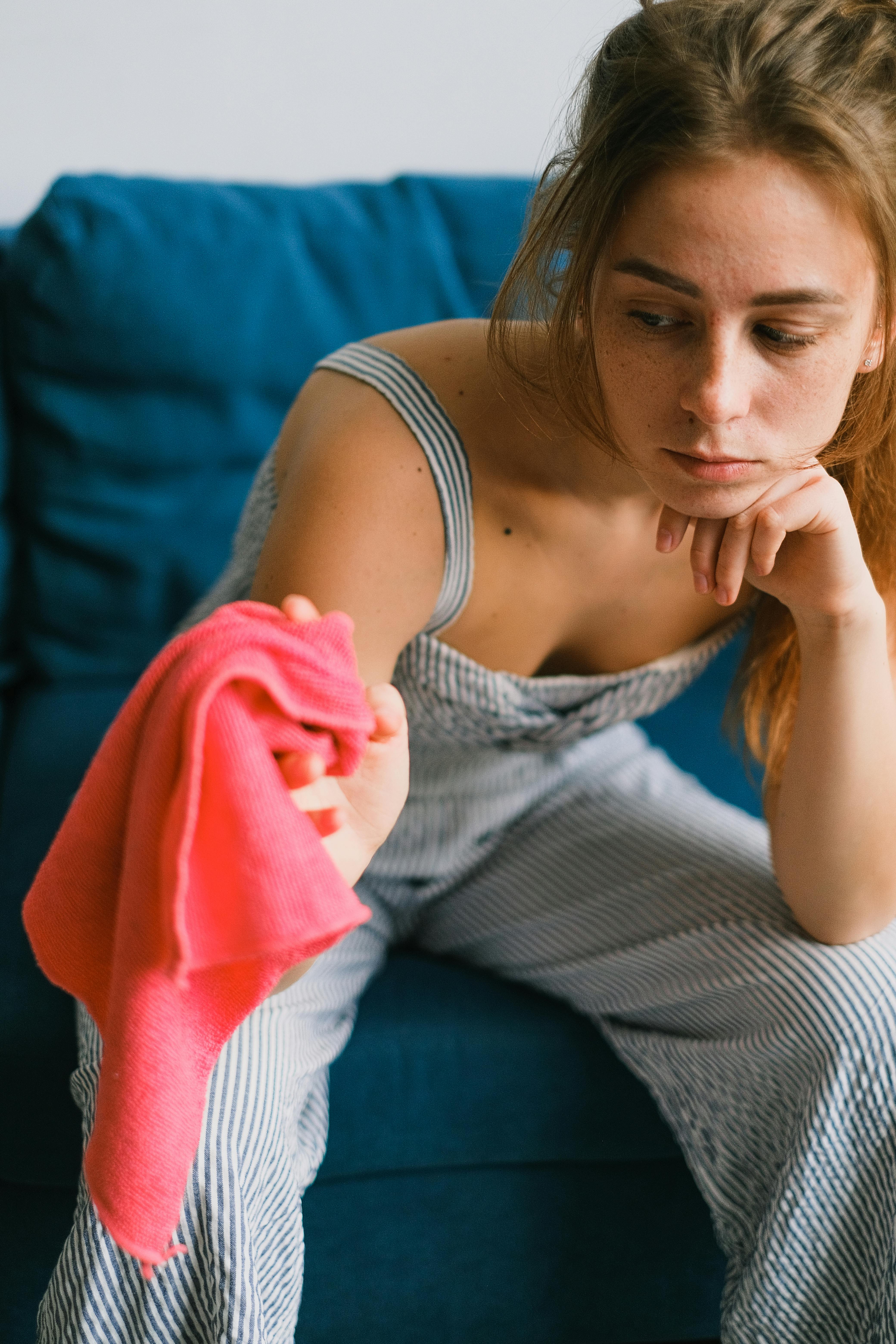 An upset and exhausted woman holding a cleaning rag | Source: Pexels