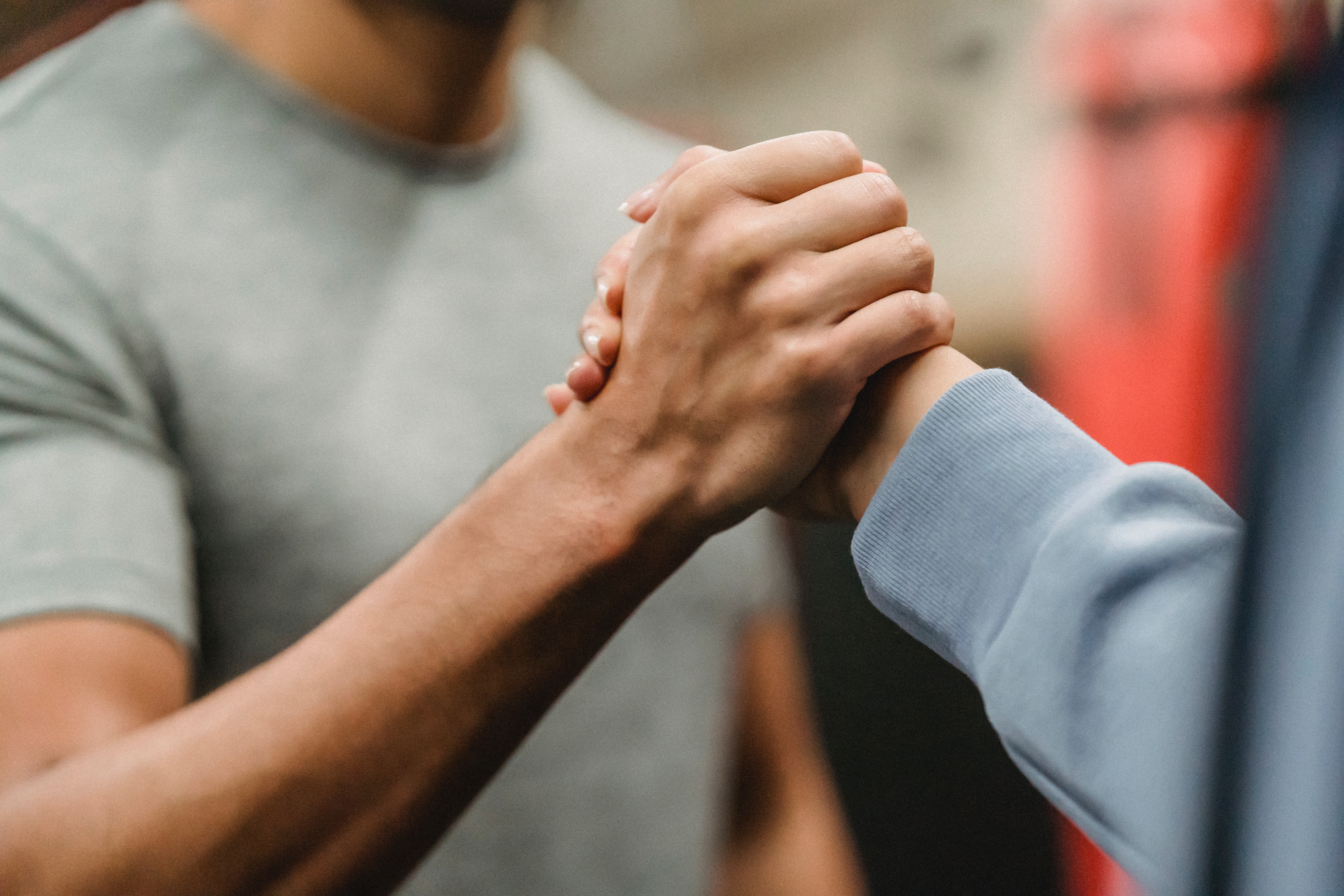 Two individuals clasping their hands together. | Source: Pexels