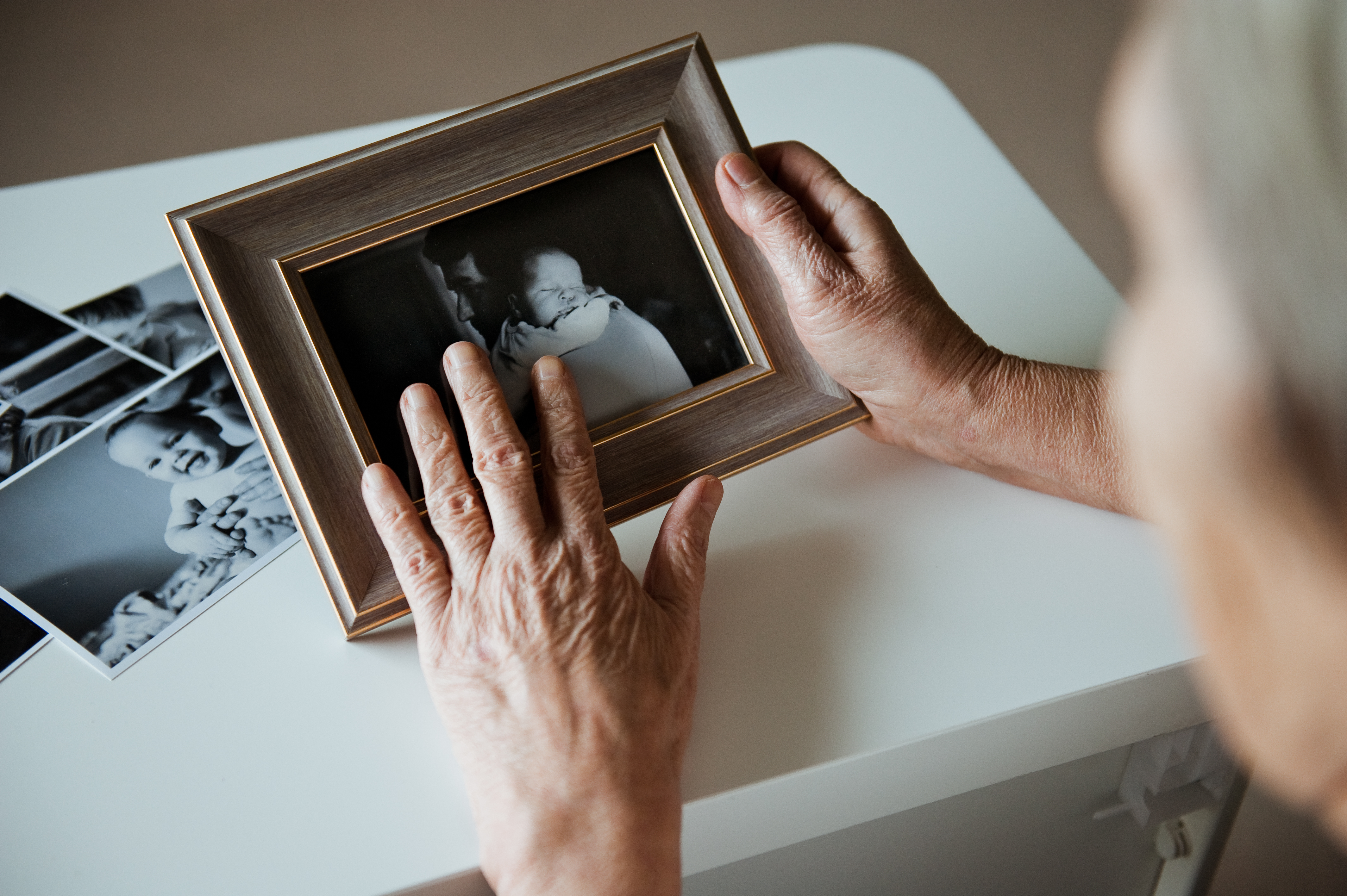 An elderly woman is holding a frame | Source: Shutterstock