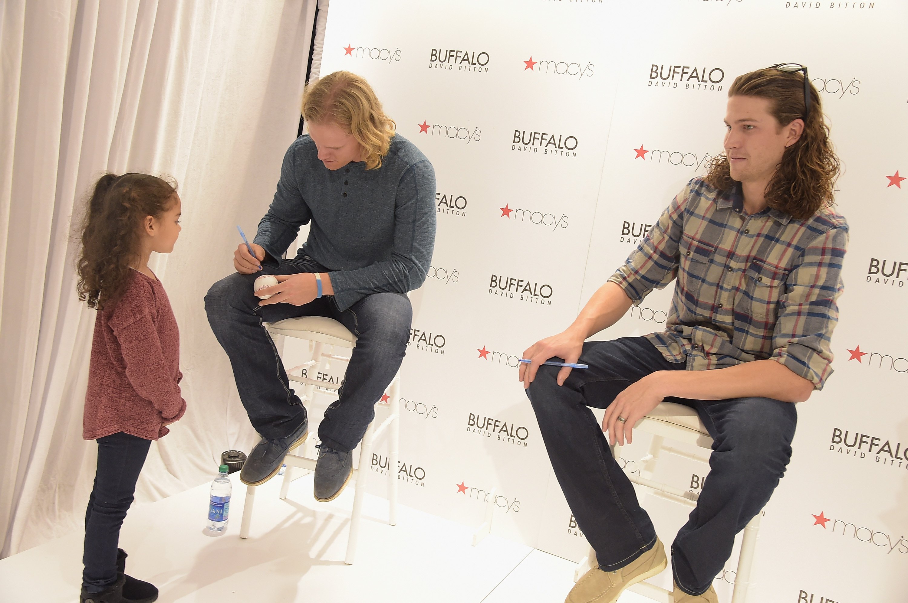 Noah Syndergaard and Jacob deGrom pose with a young fan at Macy's Herald Square in New York City on November 5, 2015. | Source: Getty Images