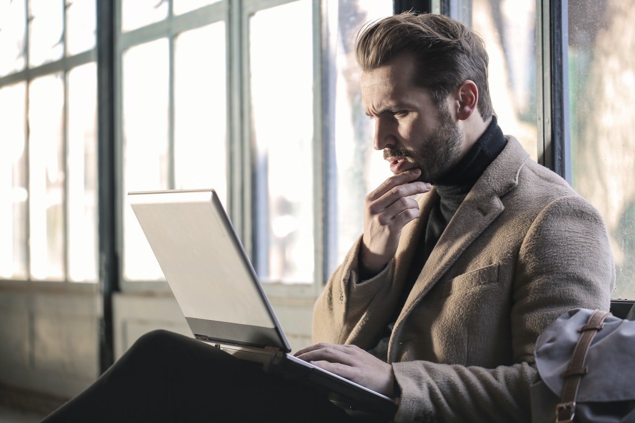A man sitting and looking at his laptop curiously | Source: Pexels