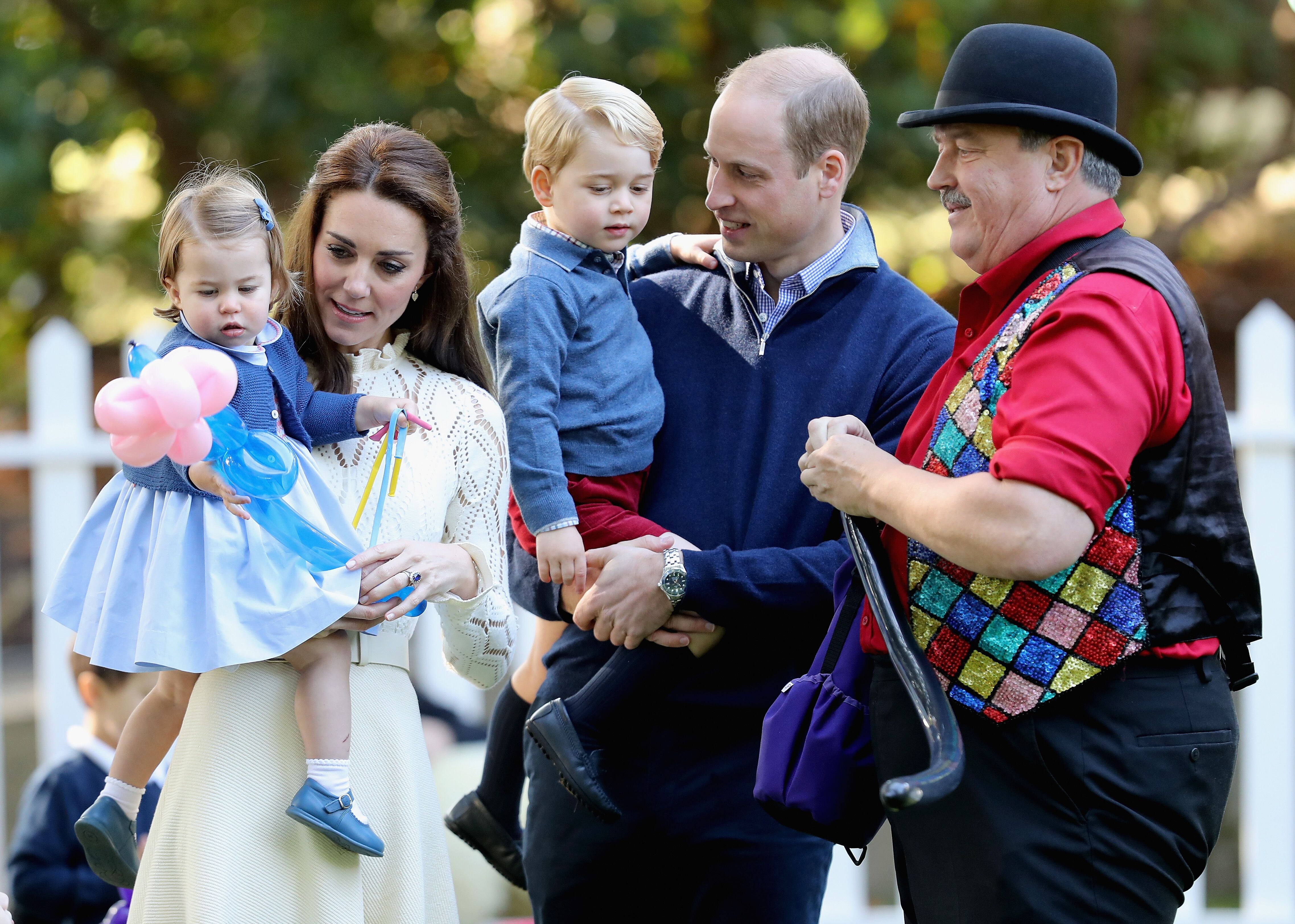 Duchess of Cambridge holding Princess Charlotte of Cambridge and Prince George of Cambridge, being held by Prince William, Duke of Cambridge at a children's party for Military families during the Royal Tour of Canada on September 29, 2016 in Victoria, Canada | Photo: Getty Images