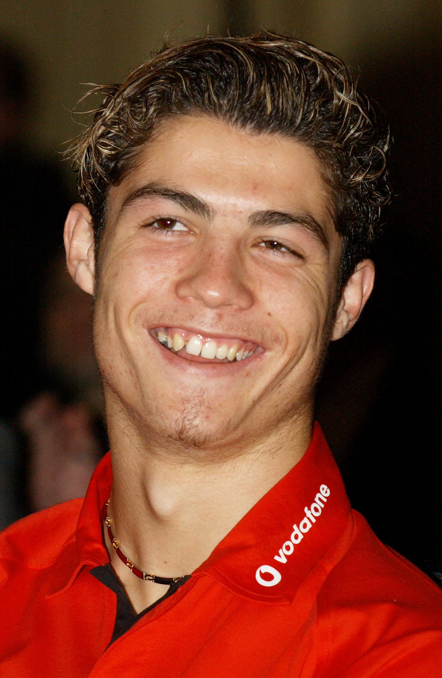 Cristiano Ronaldo smiled during a Manchester United event in London on December 1, 2003, marking the club's renewed sponsorship agreement with Vodafone. Taken just months into his Old Trafford career, the portrait highlighted his youthful features, natural smile, and signature frosted hairstyle before the polished look that later became synonymous with the global soccer icon.