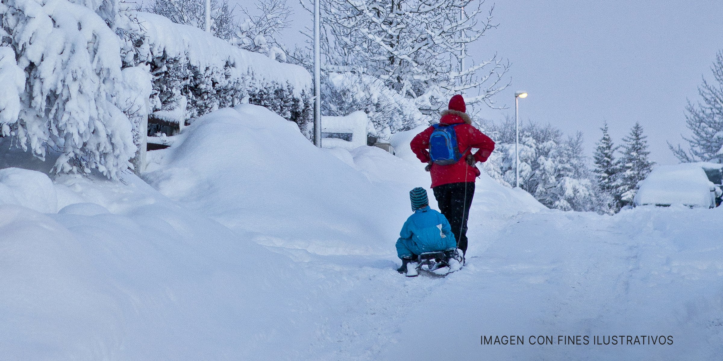 Adulto con un niño en un trineo de nieve | Foto: Shutterstock