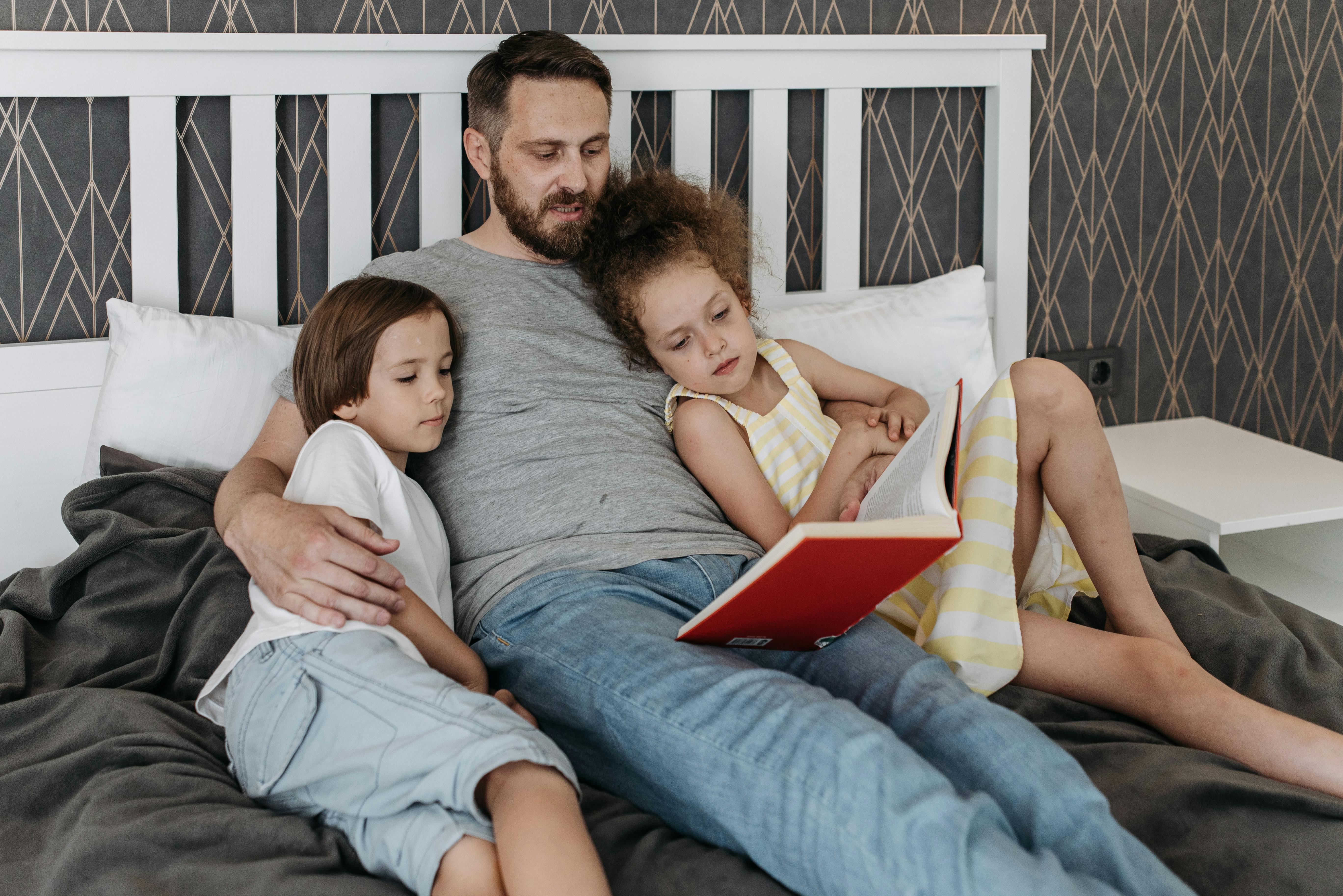 A father reading a bedtime story to his children | Source: Pexels