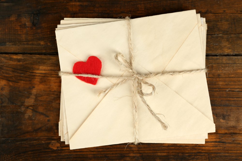 A stack of love letters on a wooden background. | Photo: Shutterstock