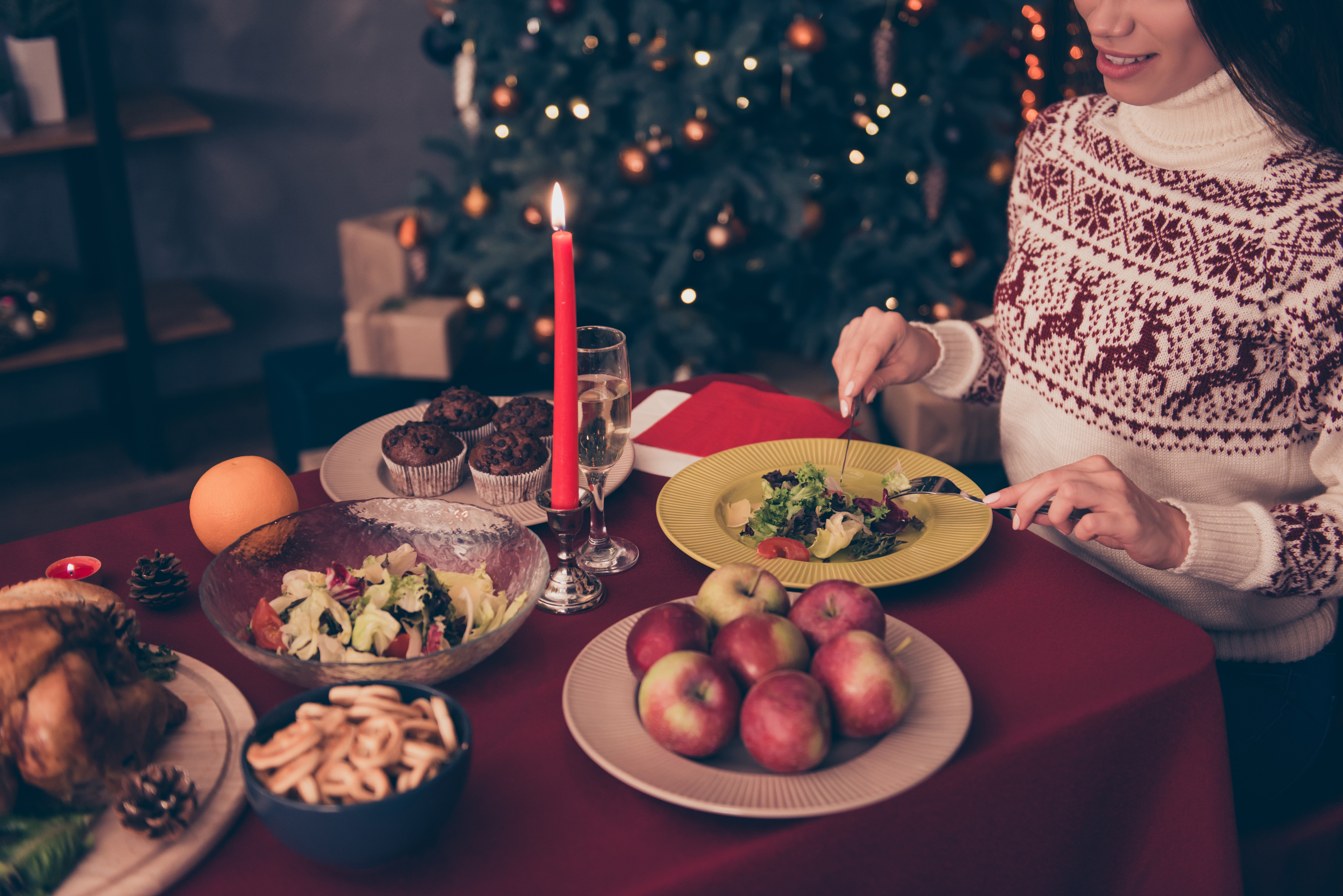 A woman eating a salad at Christmas dinner | Source: Shutterstock