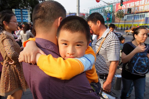 A young child with his father  on National Day Golden Week | Photo: Getty Images