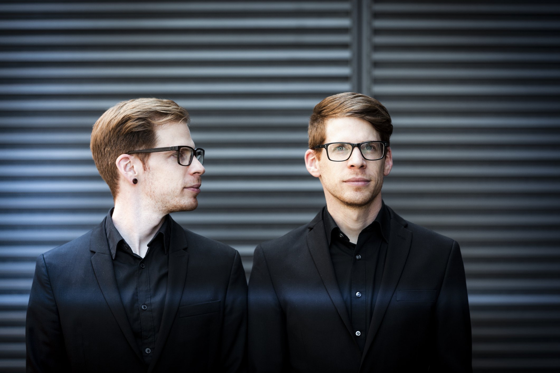 Twin brothers in black suit and glasses | Photo: Getty Images 