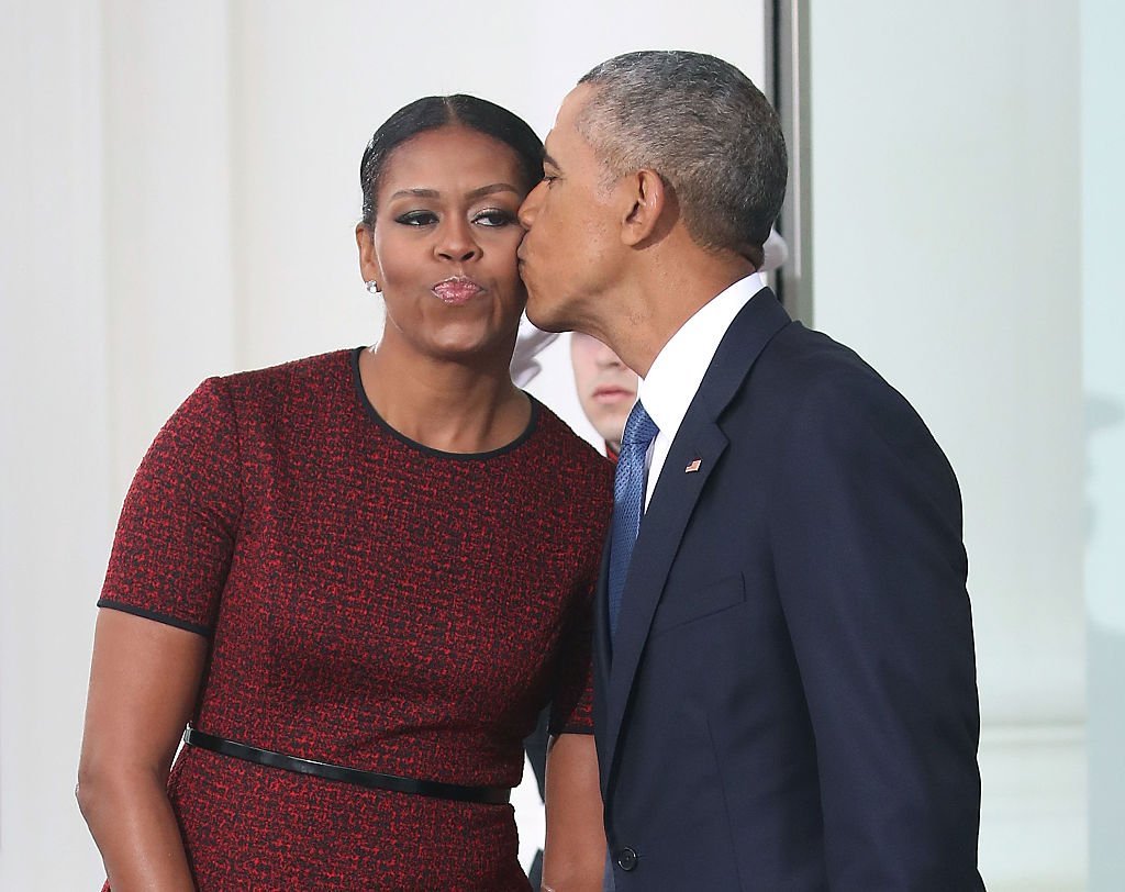 President Barack Obama gives a kiss to his wife first lady Michelle Obama before the arrival of President-elect Donald Trump and his wife Melania Trump, at the White House | Photo: Getty Images