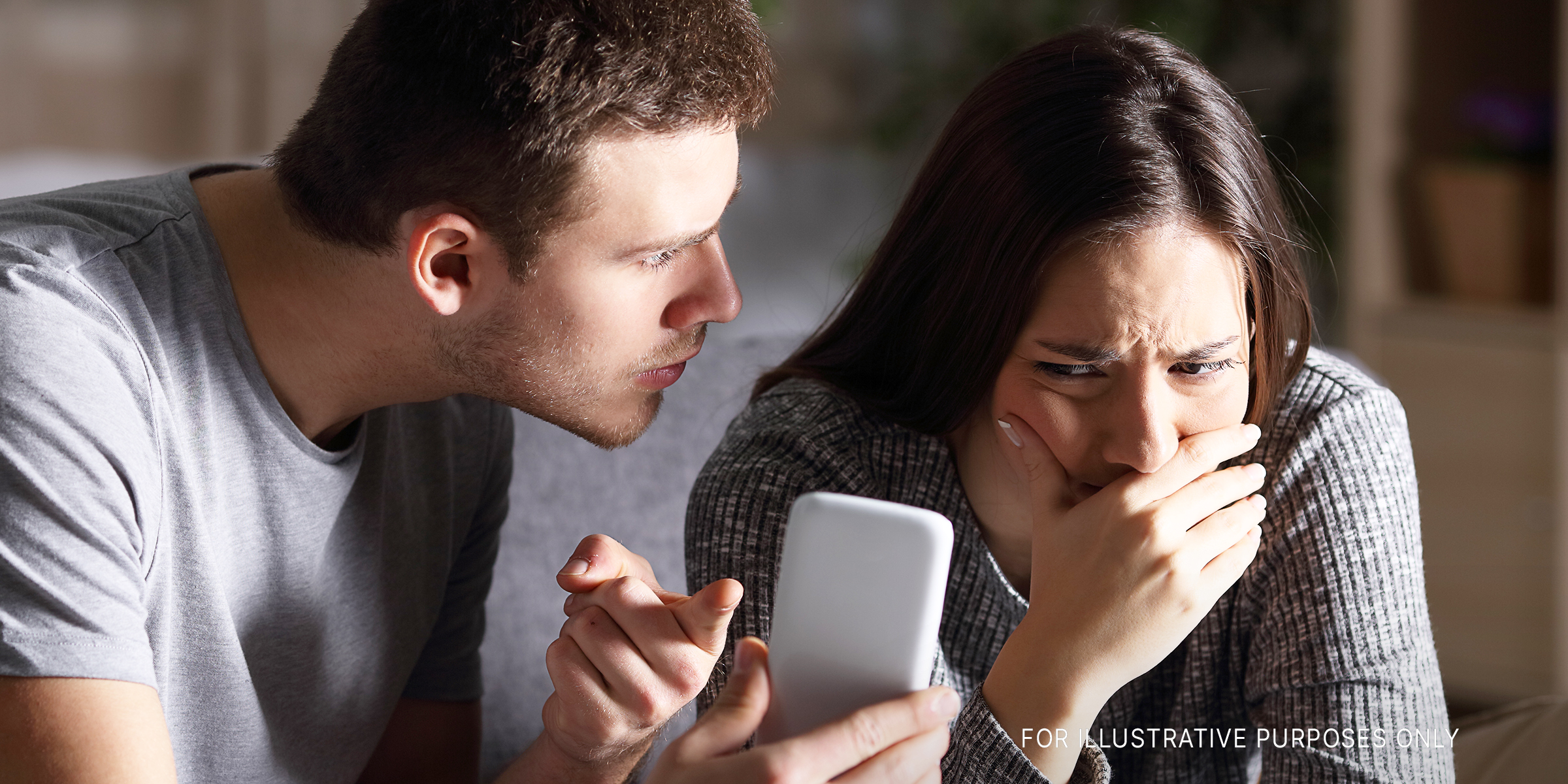 A couple having a disagreement over something on a phone | Source: Getty Images