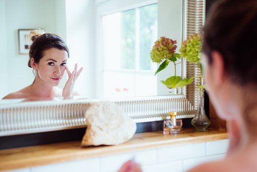 Une belle femme enlève son maquillage de son visage. | Photo : Getty Images