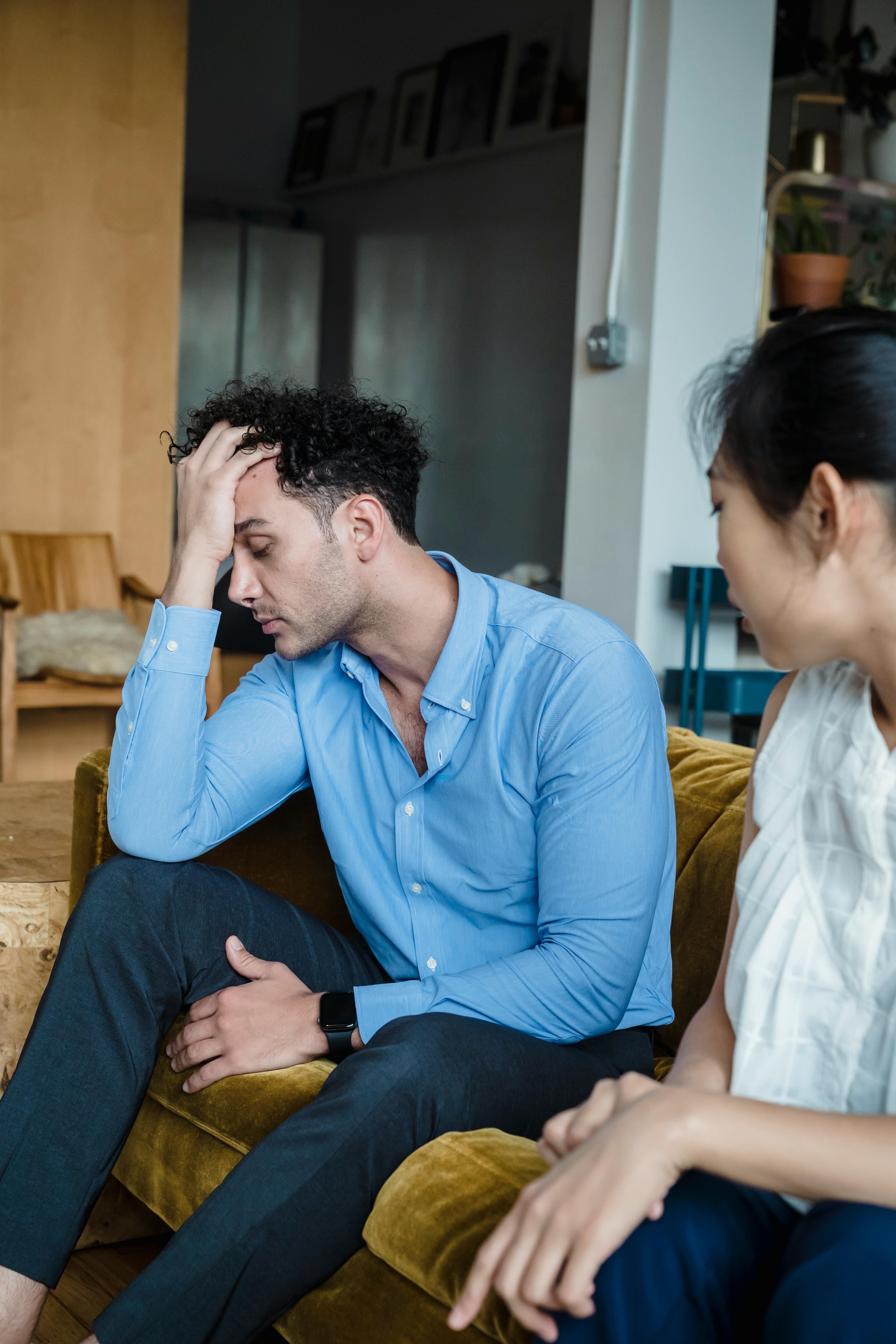 A man looking exhausted while having a difficult conversation with his partner | Source: Pexels