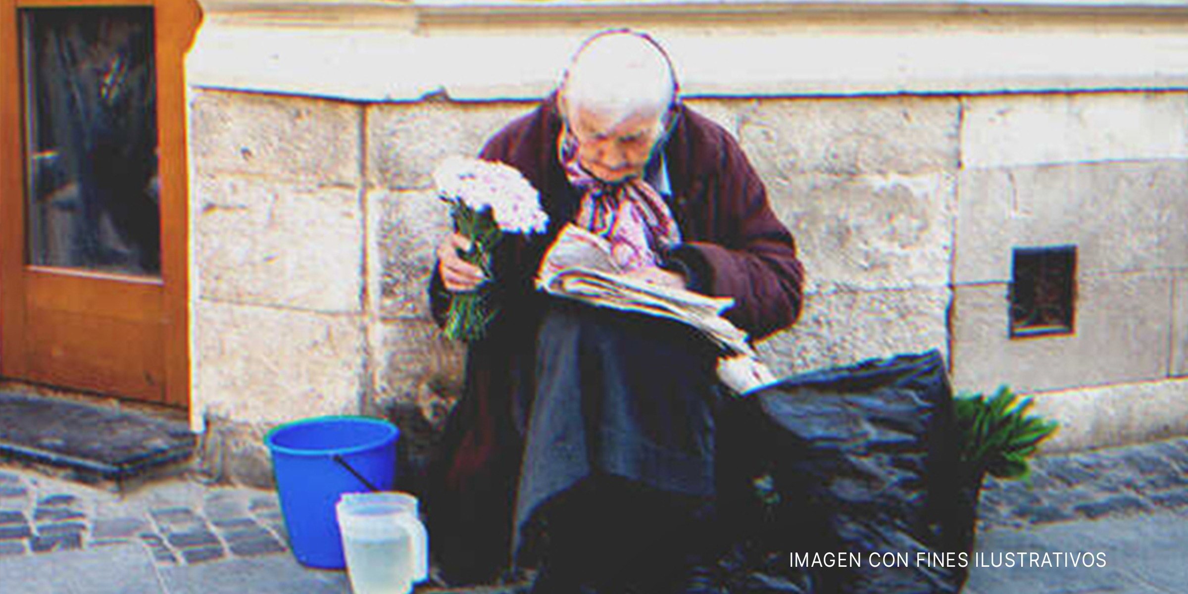 Anciana sentada en una acera con un ramo de flores en su mano. | Foto: Shutterstock