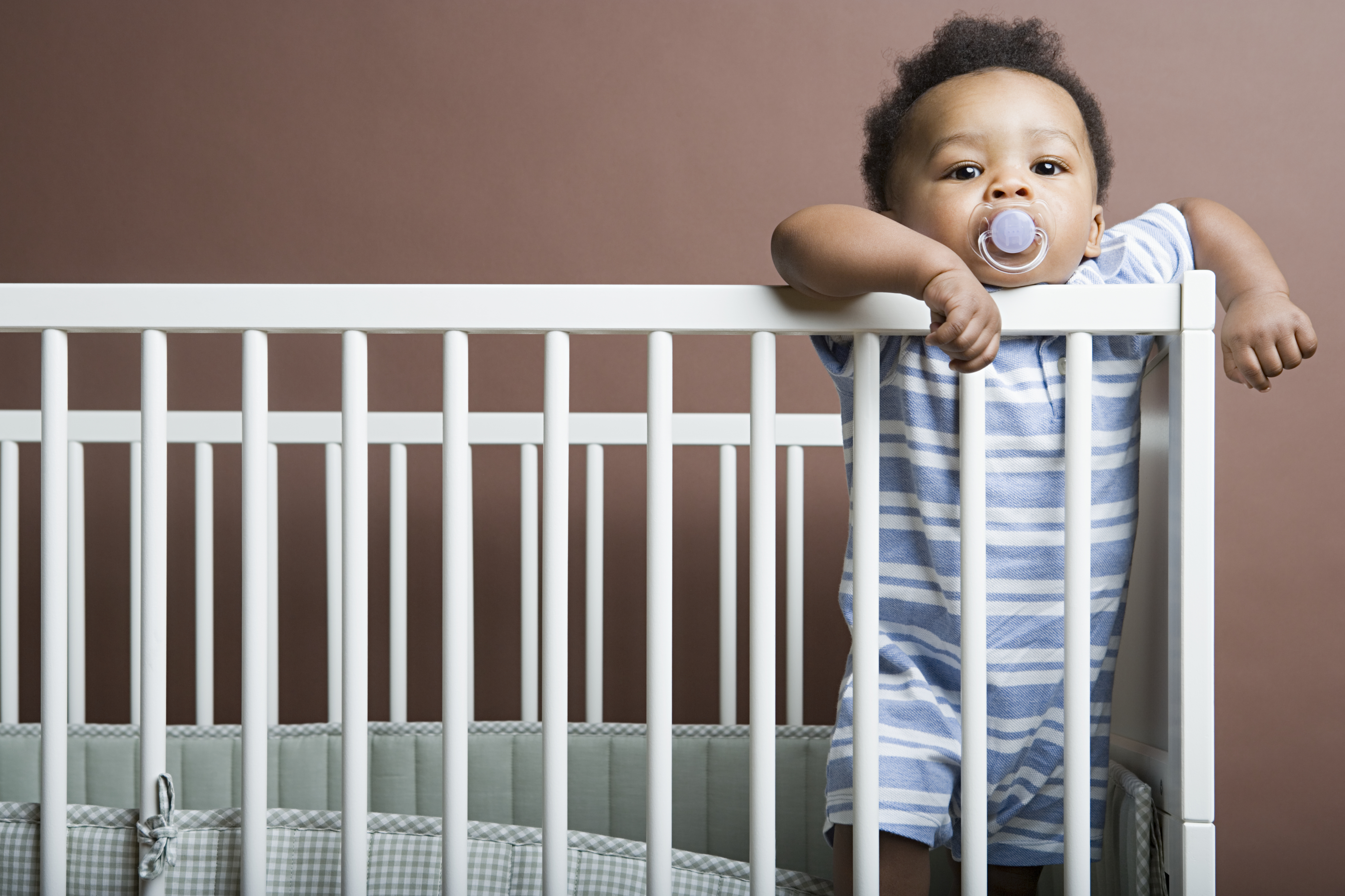 A baby standing in his crib | Source: Getty Images