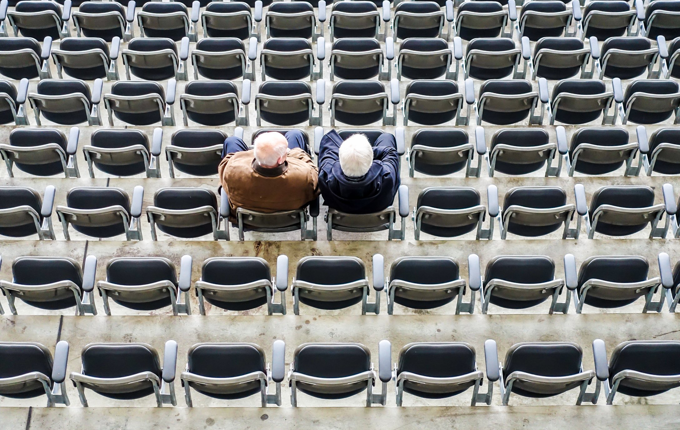 Hochwinkelaufnahme von Freunden, die in einem Stadion sitzen | Quelle: Getty Images