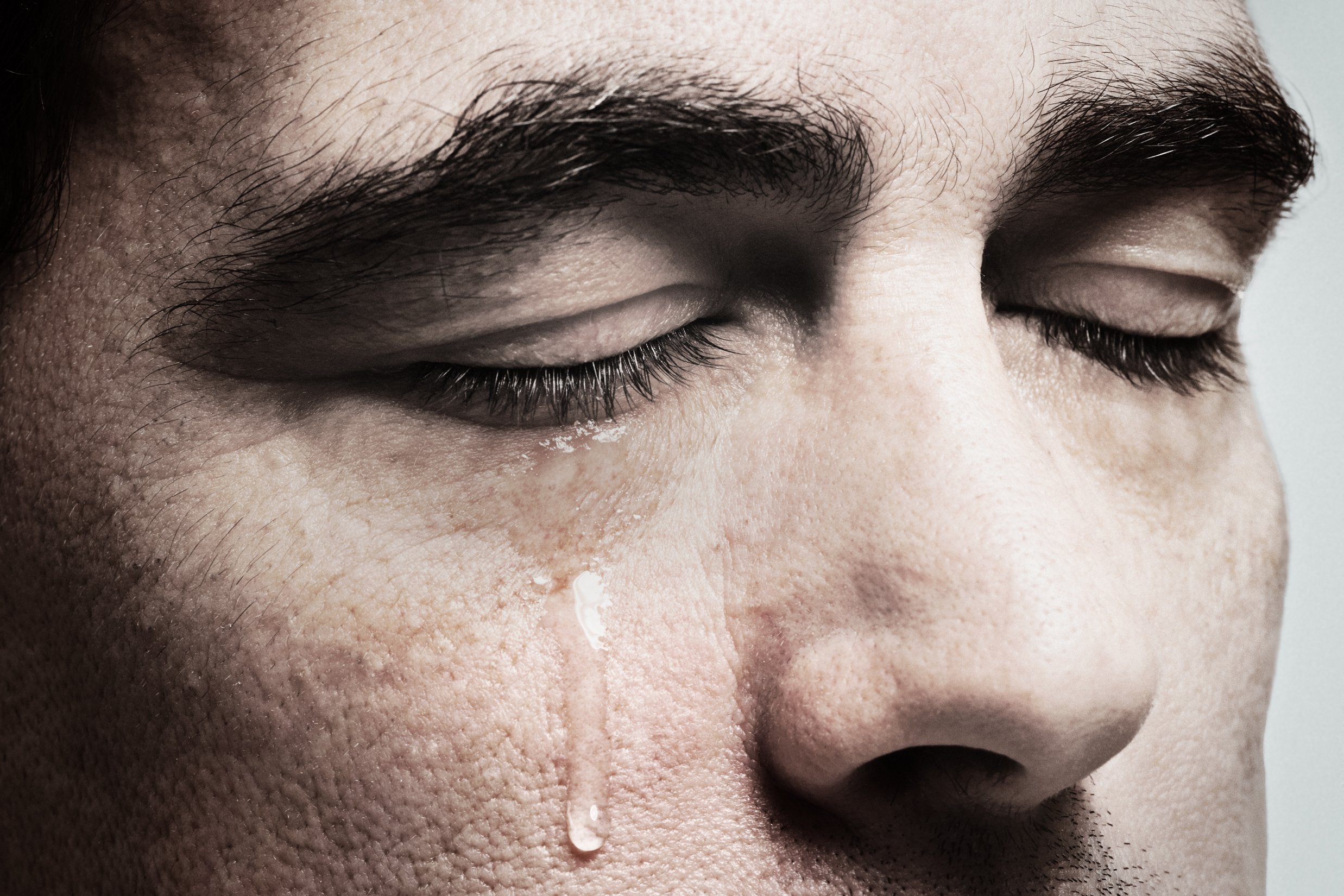 A closeup of a man crying | Source: Shutterstock