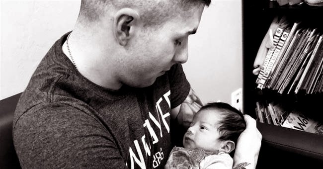 Soldier holds the baby he believed belonged to him. | Source: twitter.com/Newsweek