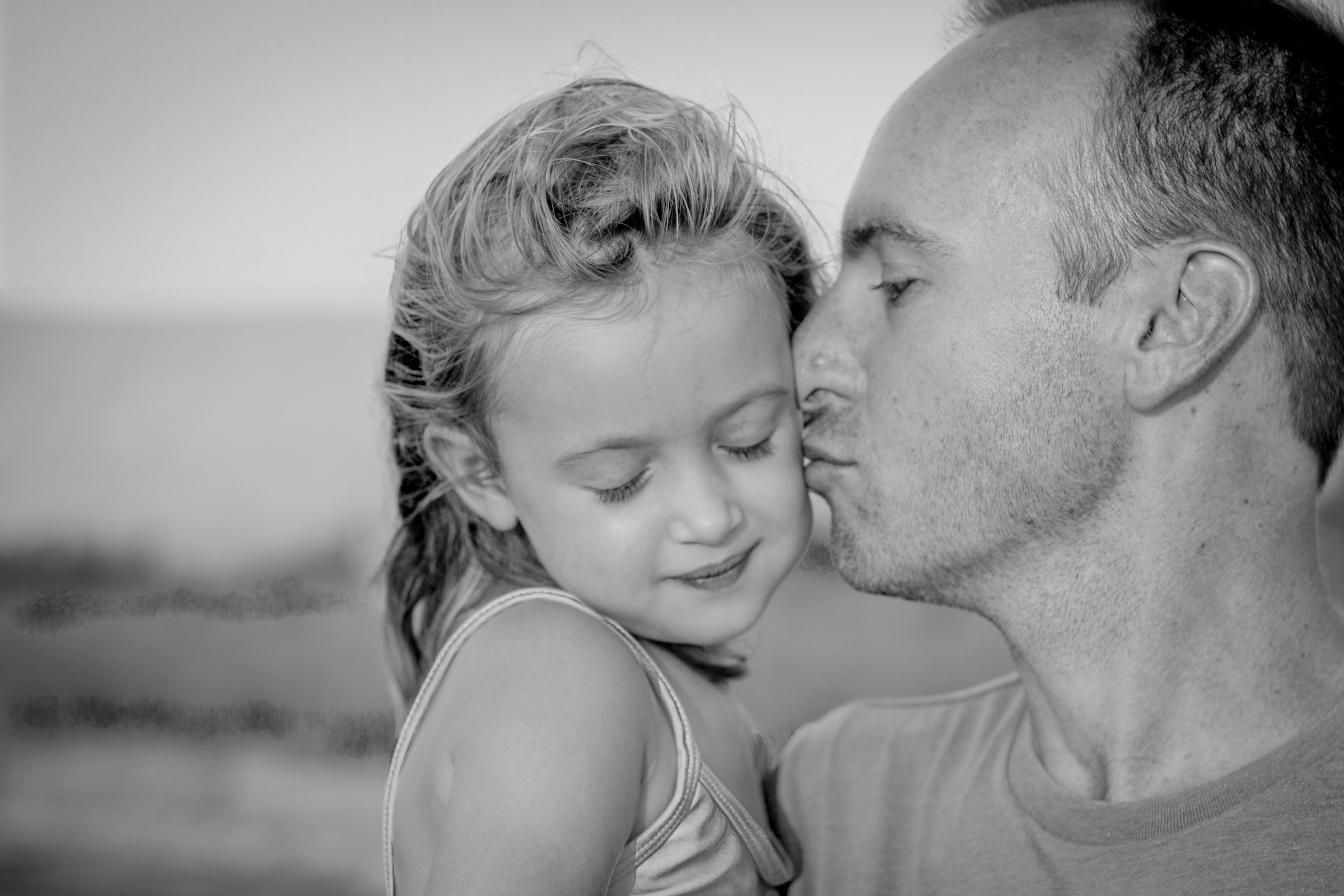 Father kissing his daughter on the cheek | Source: Unsplash