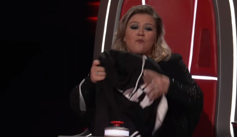 Kelly Clarkson presenting a "Welcome To Team Kelly" shirt to Marlow | Photo: YouTube/The Voice