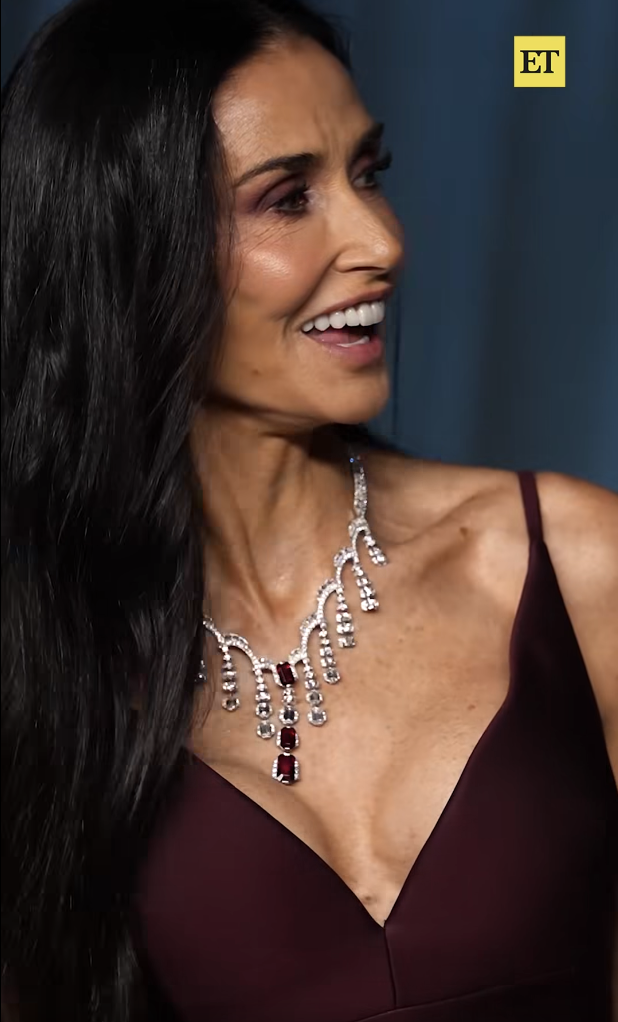 Caught mid-laugh, Demi Moore turns to her right in a candid moment, her expression full of warmth as light reflects off her statement necklace and the rich tones of her maroon gown. | Source: Facebook/EntertainmentTonight