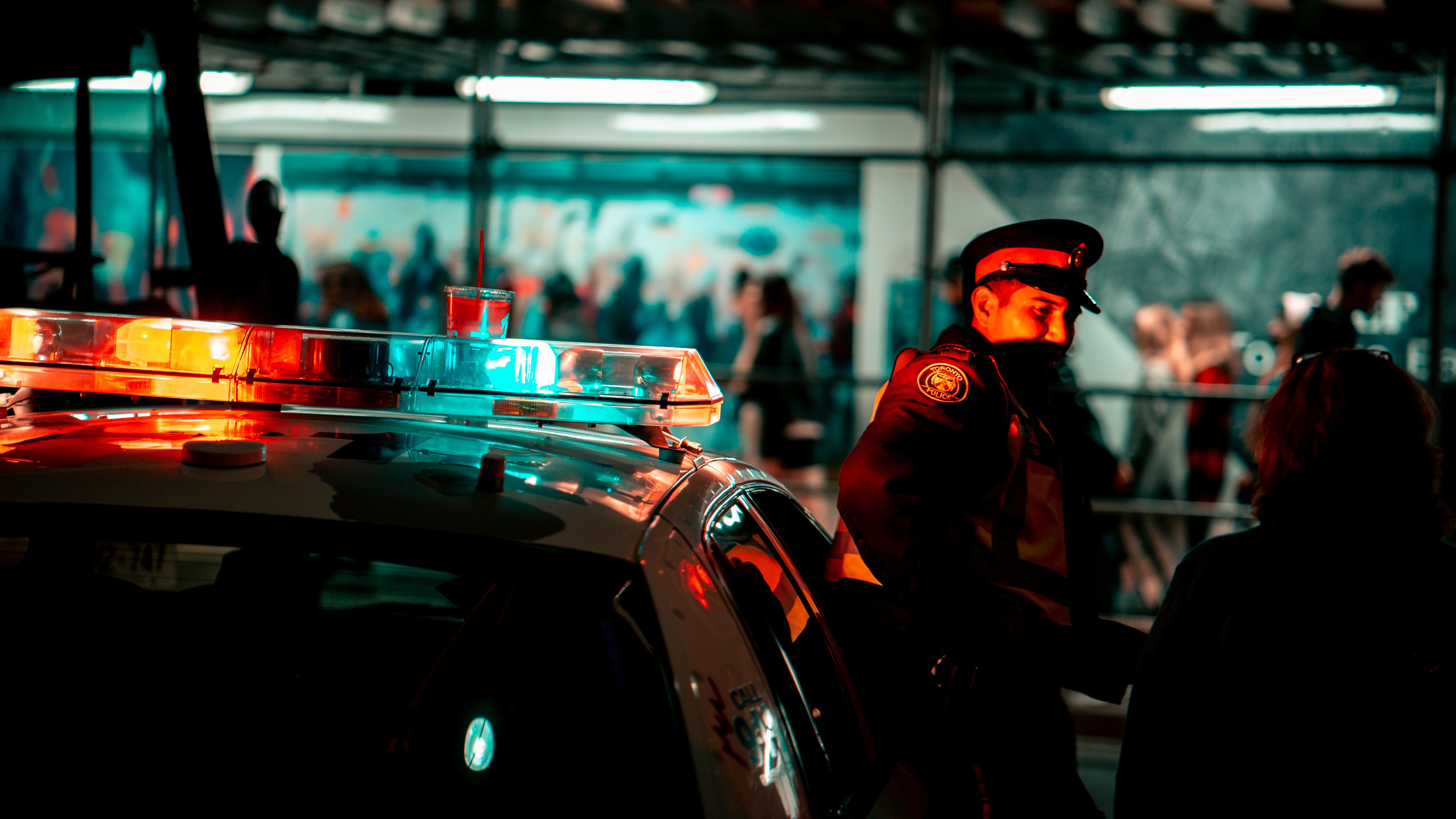 Pictured - An image of a police officer in uniform standing next to a police vehicle with siren lights on | Source: Pexels 