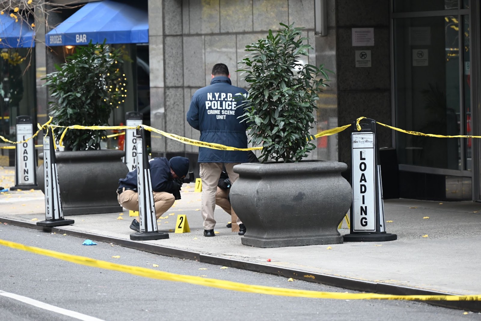 Police officers investigating the scene where UnitedHealthcare CEO Brian Thompson was fatally shot in Midtown Manhattan near a hotel on 54th Street between 6th and 7th Avenues on December 4, 2024, in New York. | Source: Getty Images