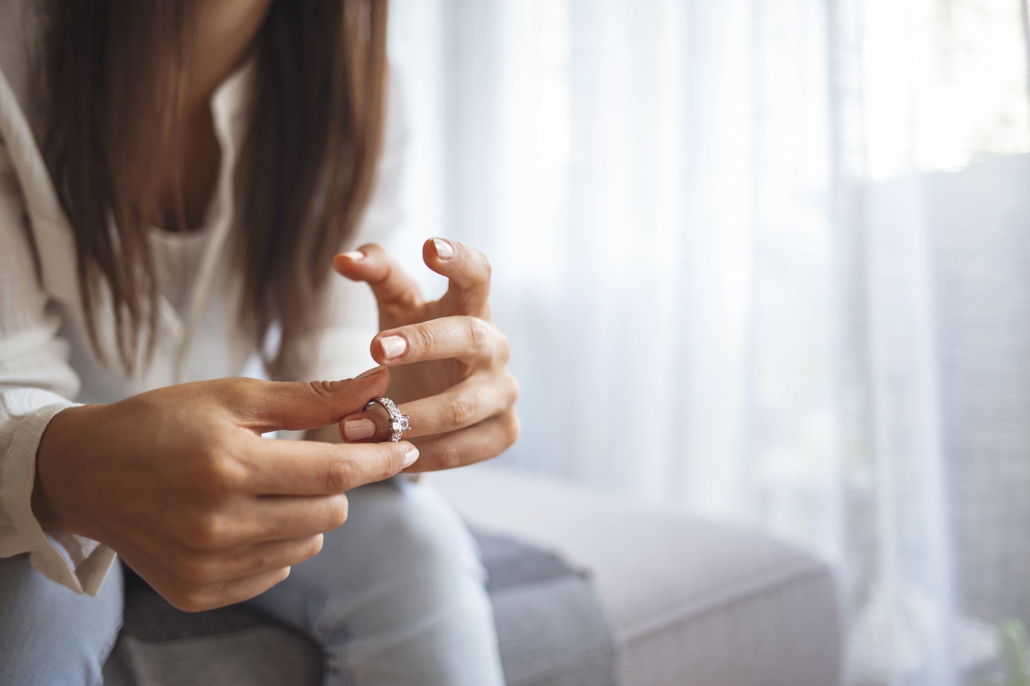 Verärgerte depressive junge Frau, die Ehering hält | Quelle: Getty Images