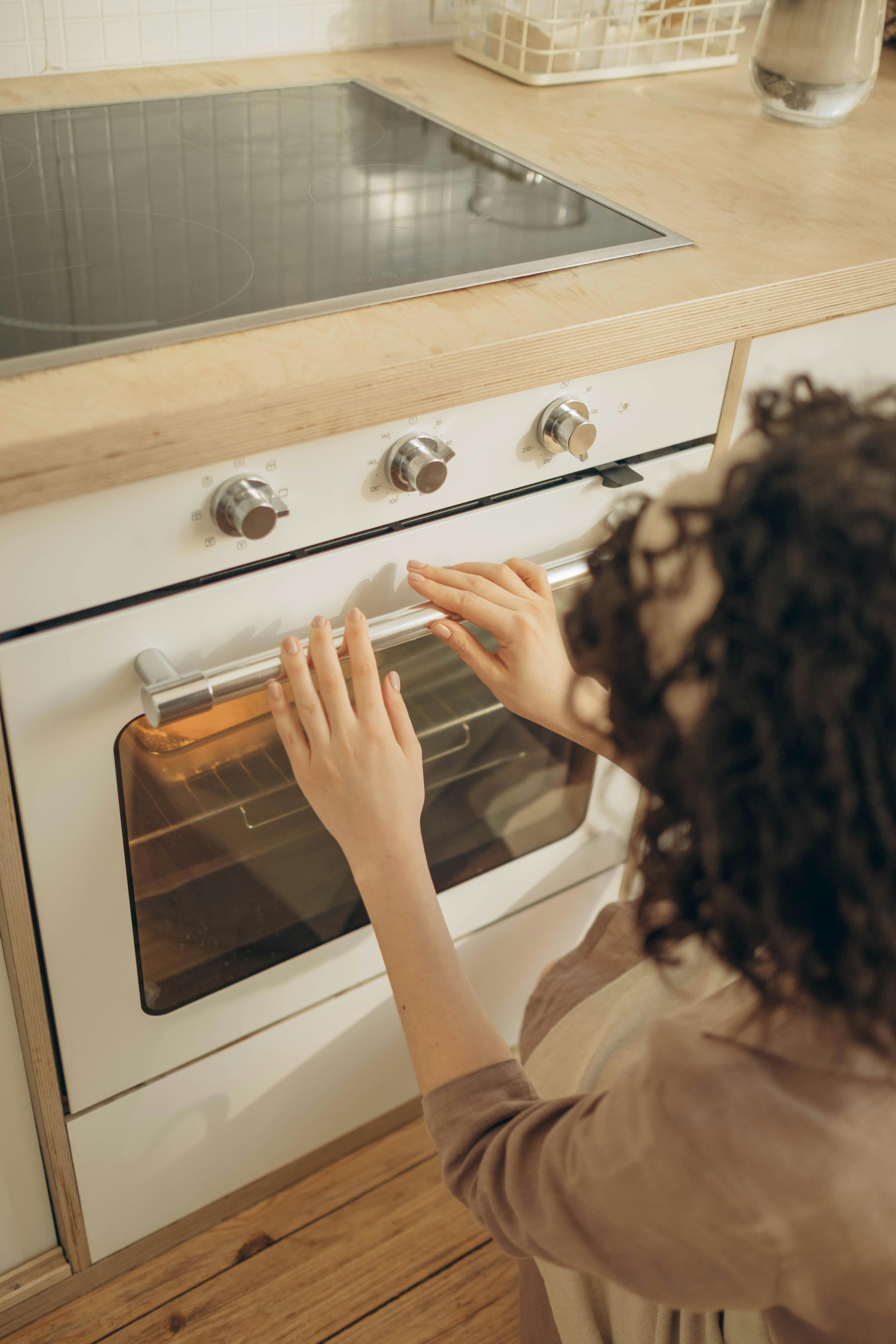 A woman checking on her oven | Source: Pexels