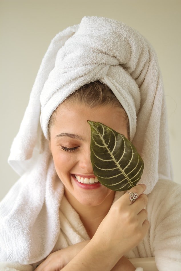 Une femme ayant entouré ses cheveux d'une serviette. l Source : Unsplash