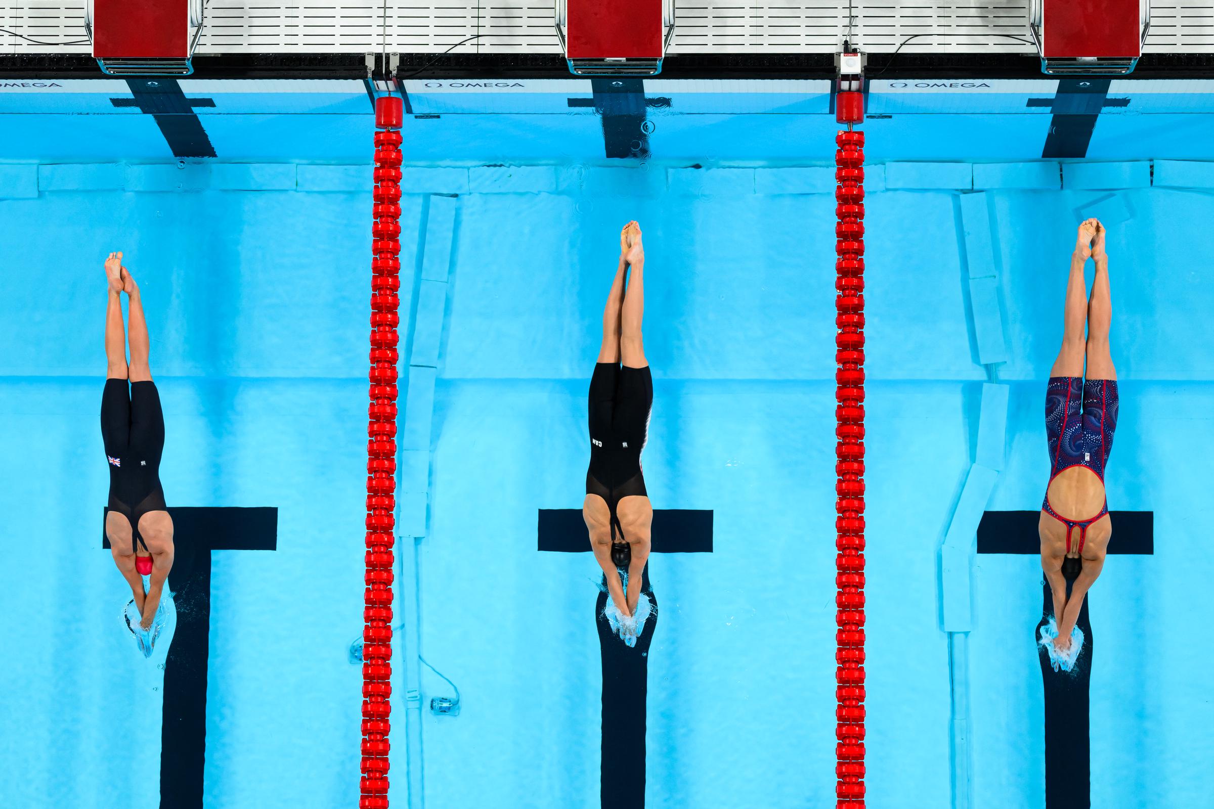 An overview shows Abbie Wood, Summer Mcintosh, and Alex Walsh competing in the final of the women's 200m individual medley swimming event at the Paris 2024 Olympic Games in Nanterre, Paris, on August 3, 2024. | Source: Getty Images